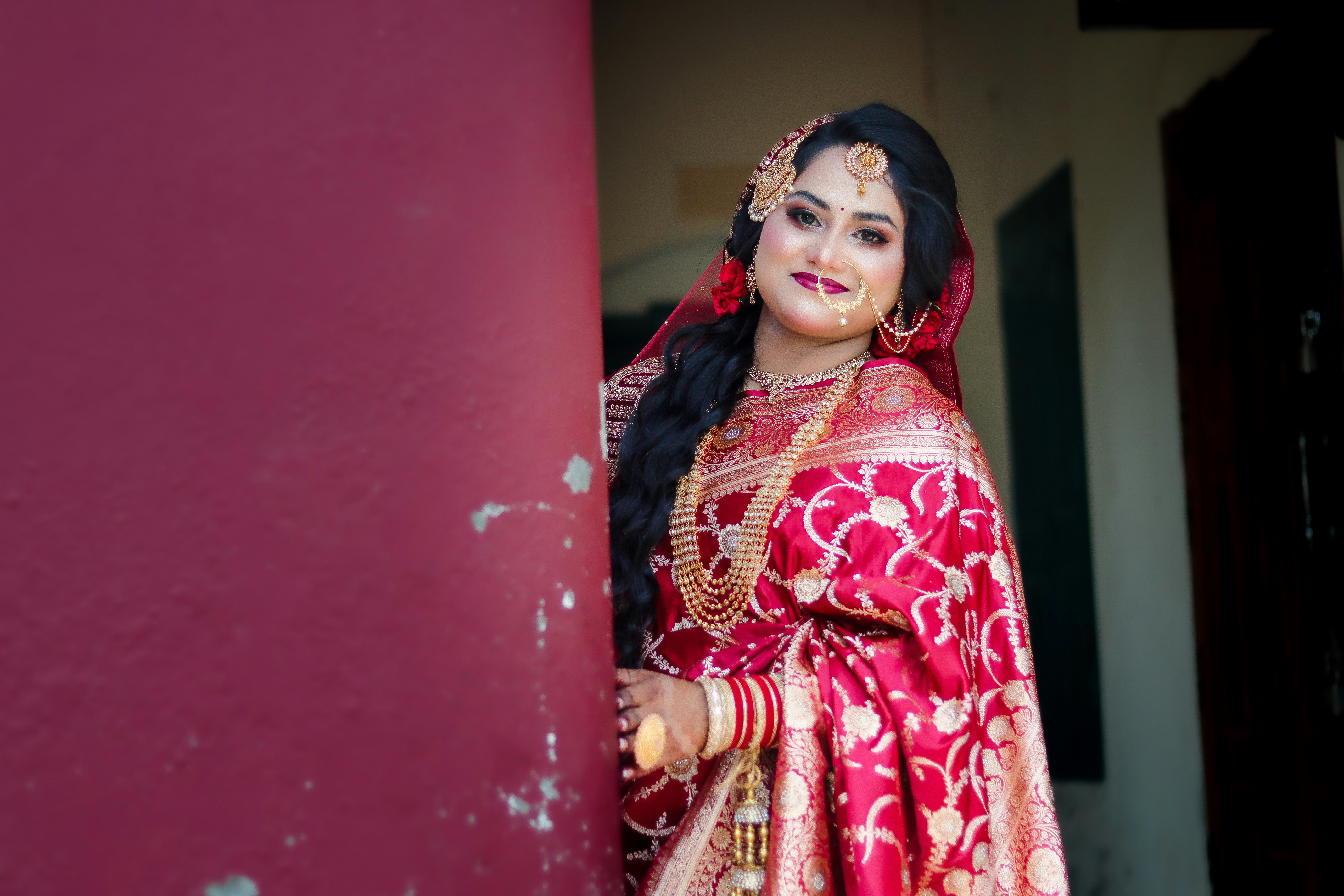 Beautiful woman in traditional red attire with gold jewelry.