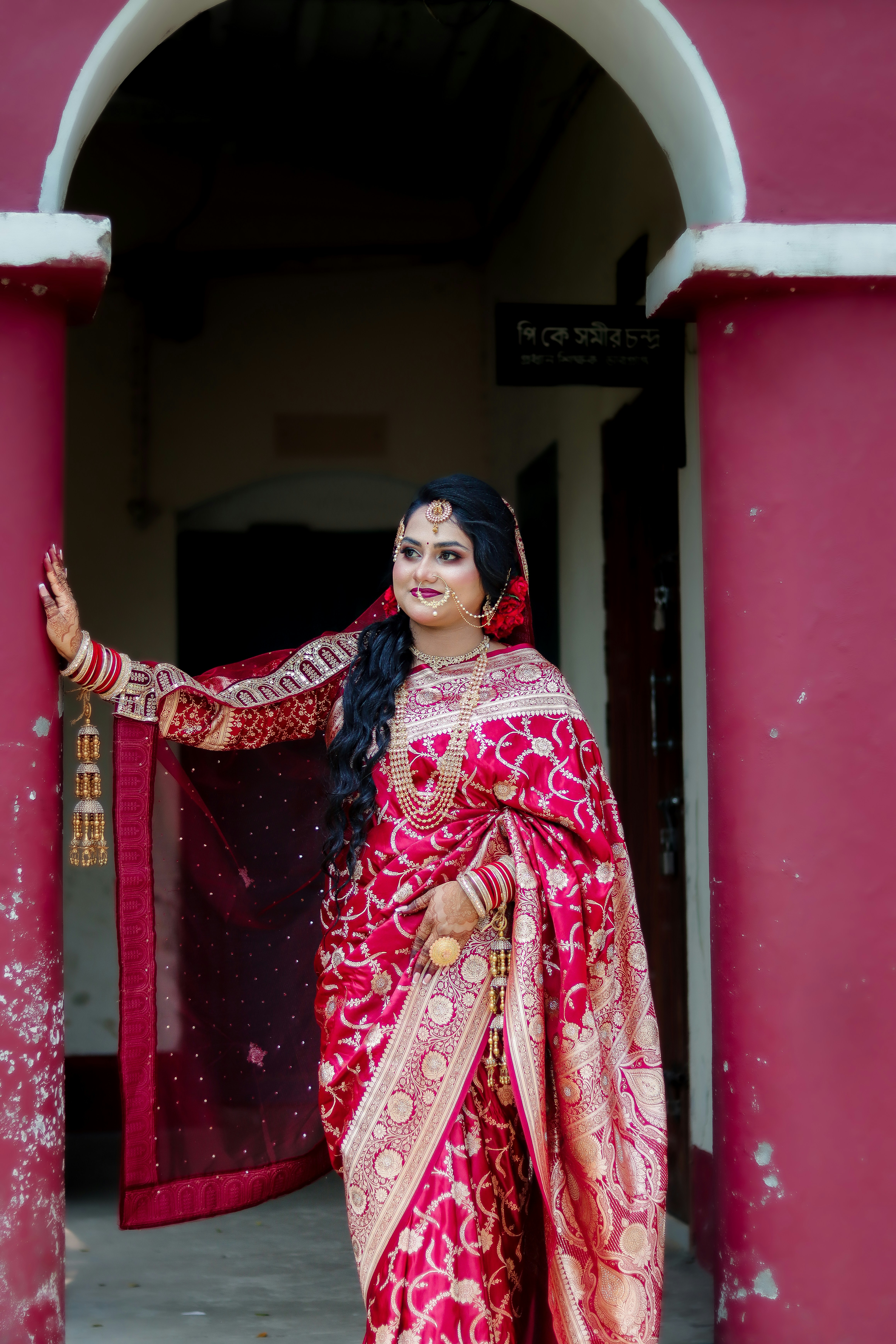 Elegant woman in red traditional attire with elaborate jewelry.