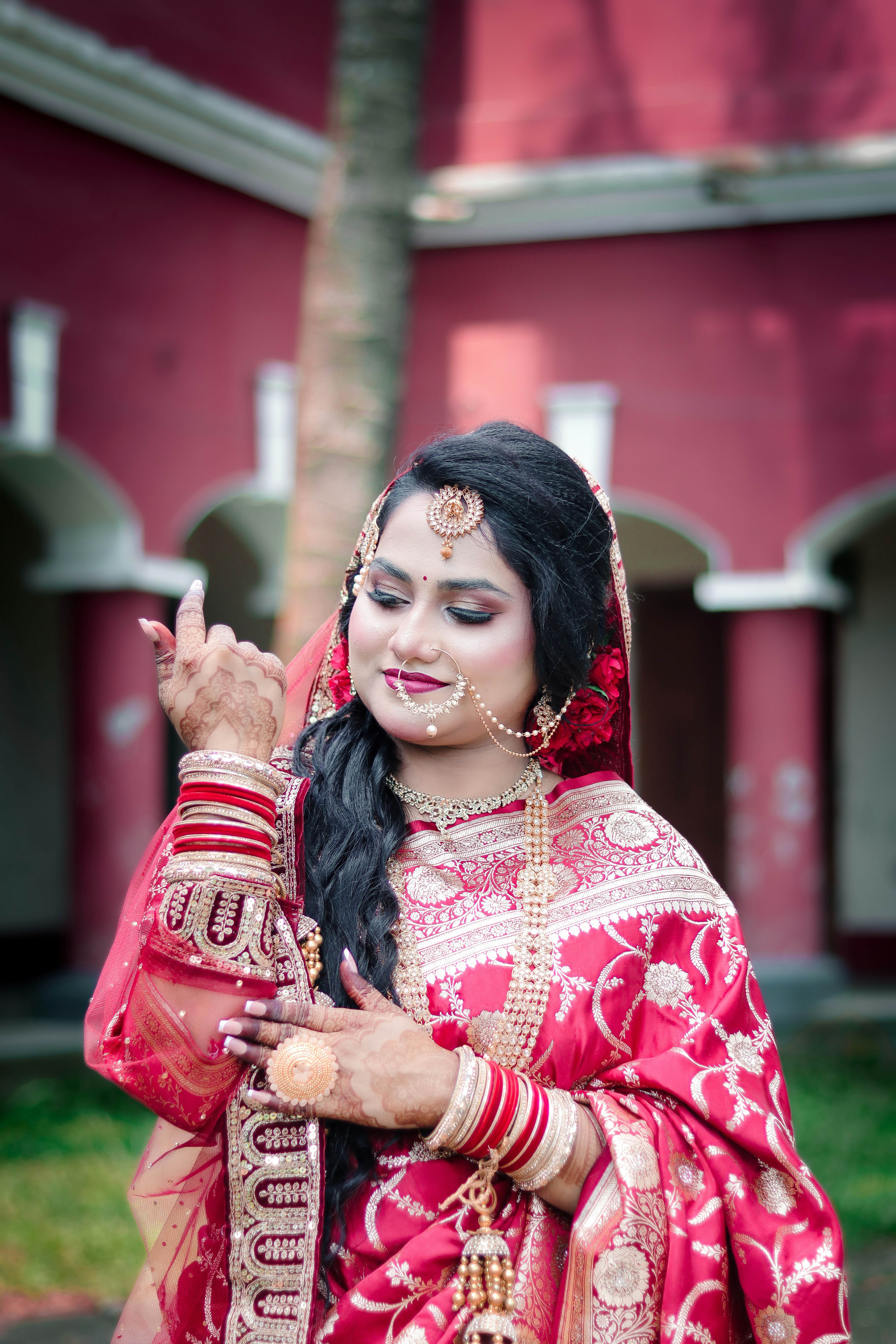 A beautiful woman in traditional red bridal attire and jewelry.