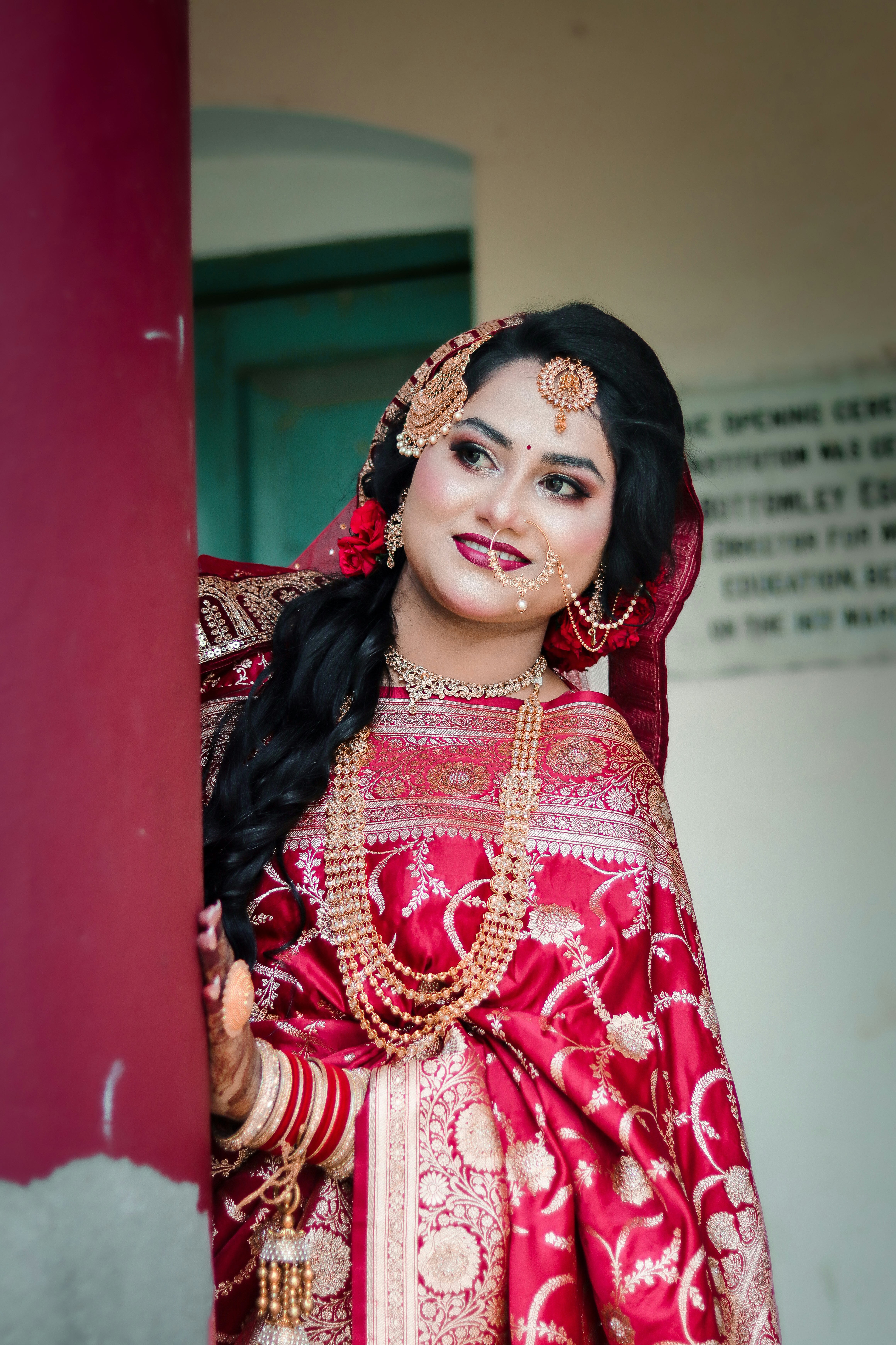 Elegant woman in red traditional dress and gold jewelry.