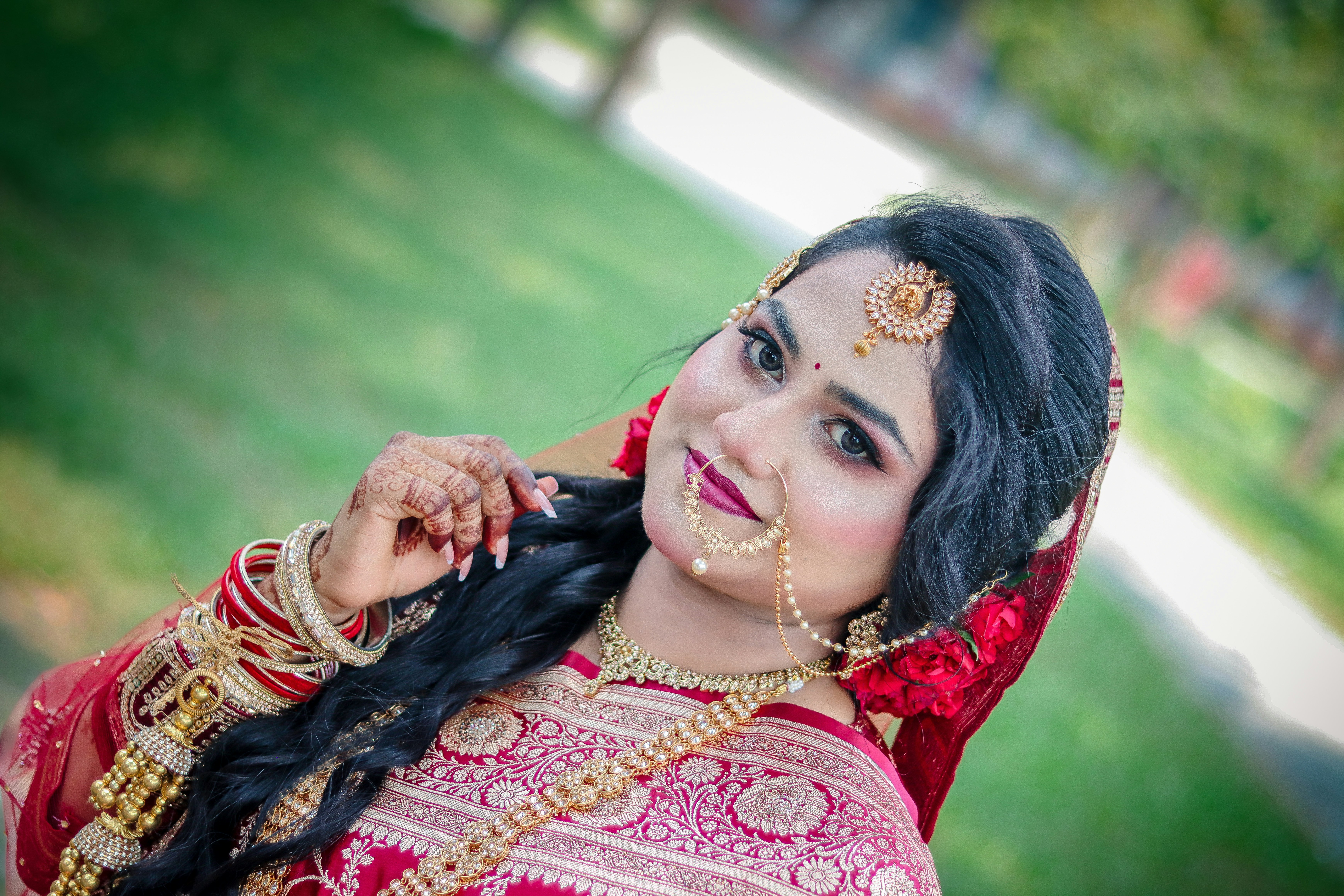 Beautiful indian bride in traditional red attire and ornate jewelry.
