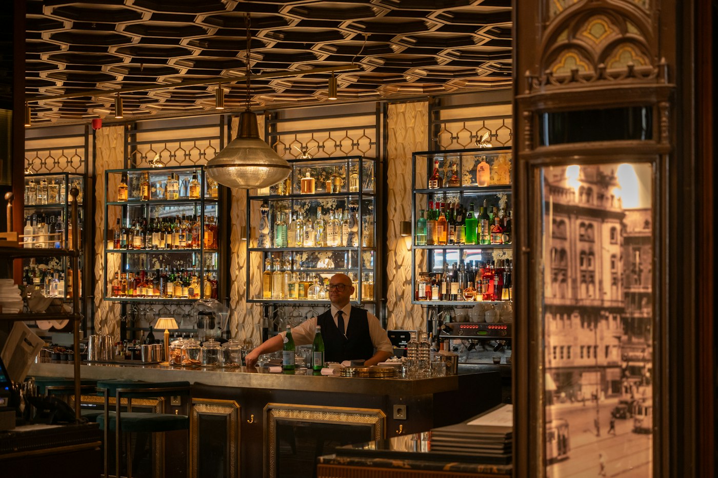 A bartender working behind an ornate bar