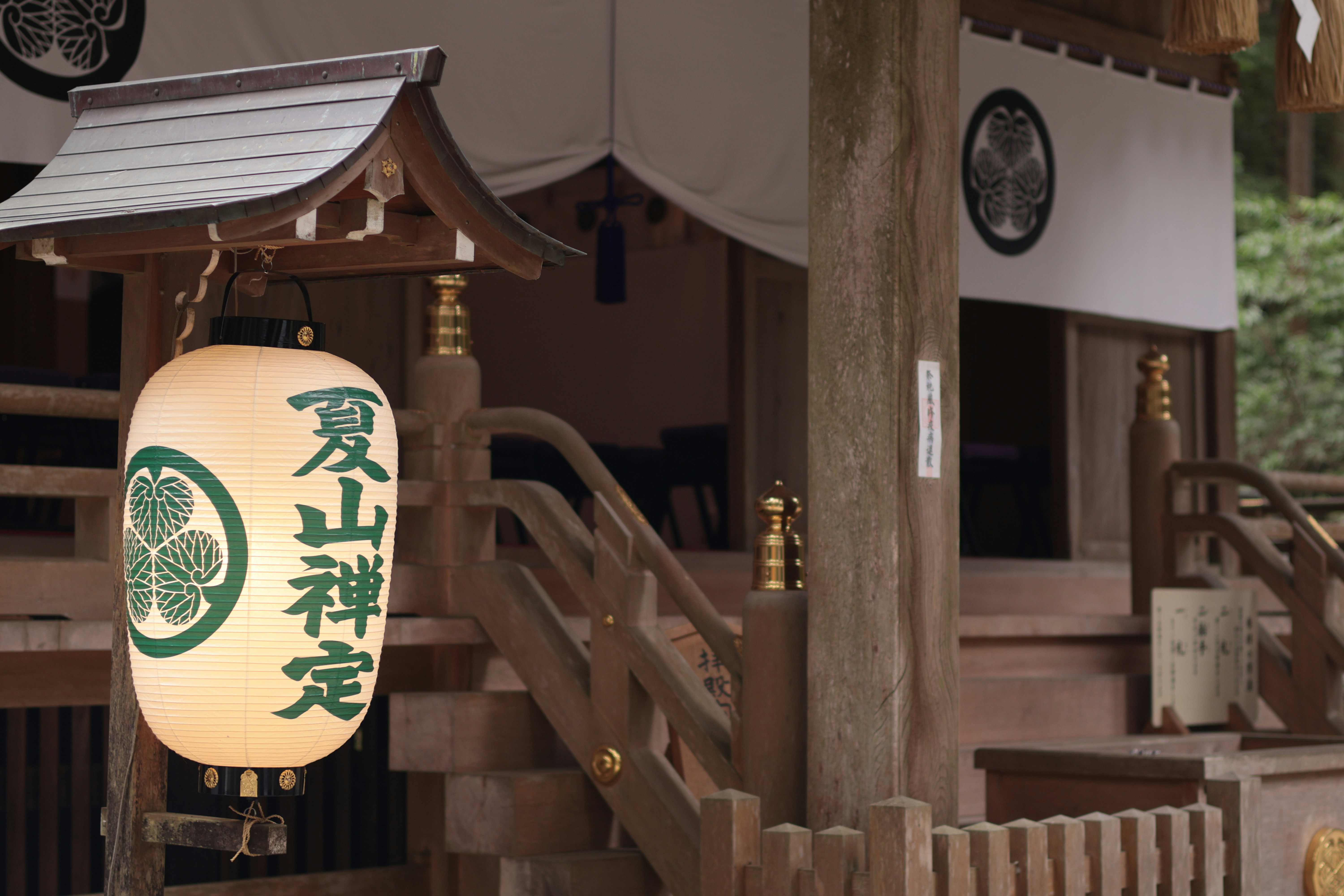 Edificio tradicional de santuarios japoneses con una linterna colgante.