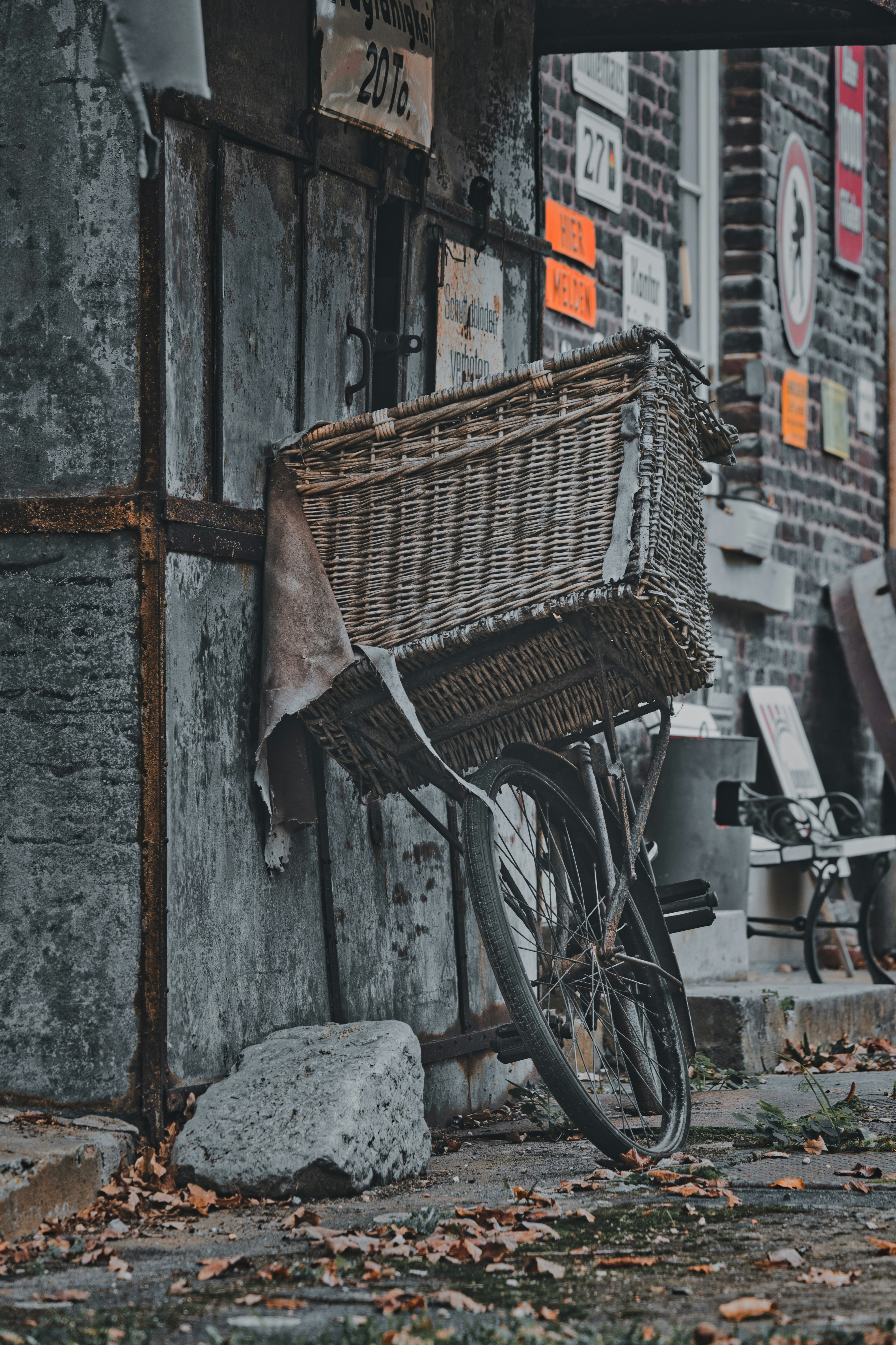Vintage bicycle with large wicker basket against an old building.