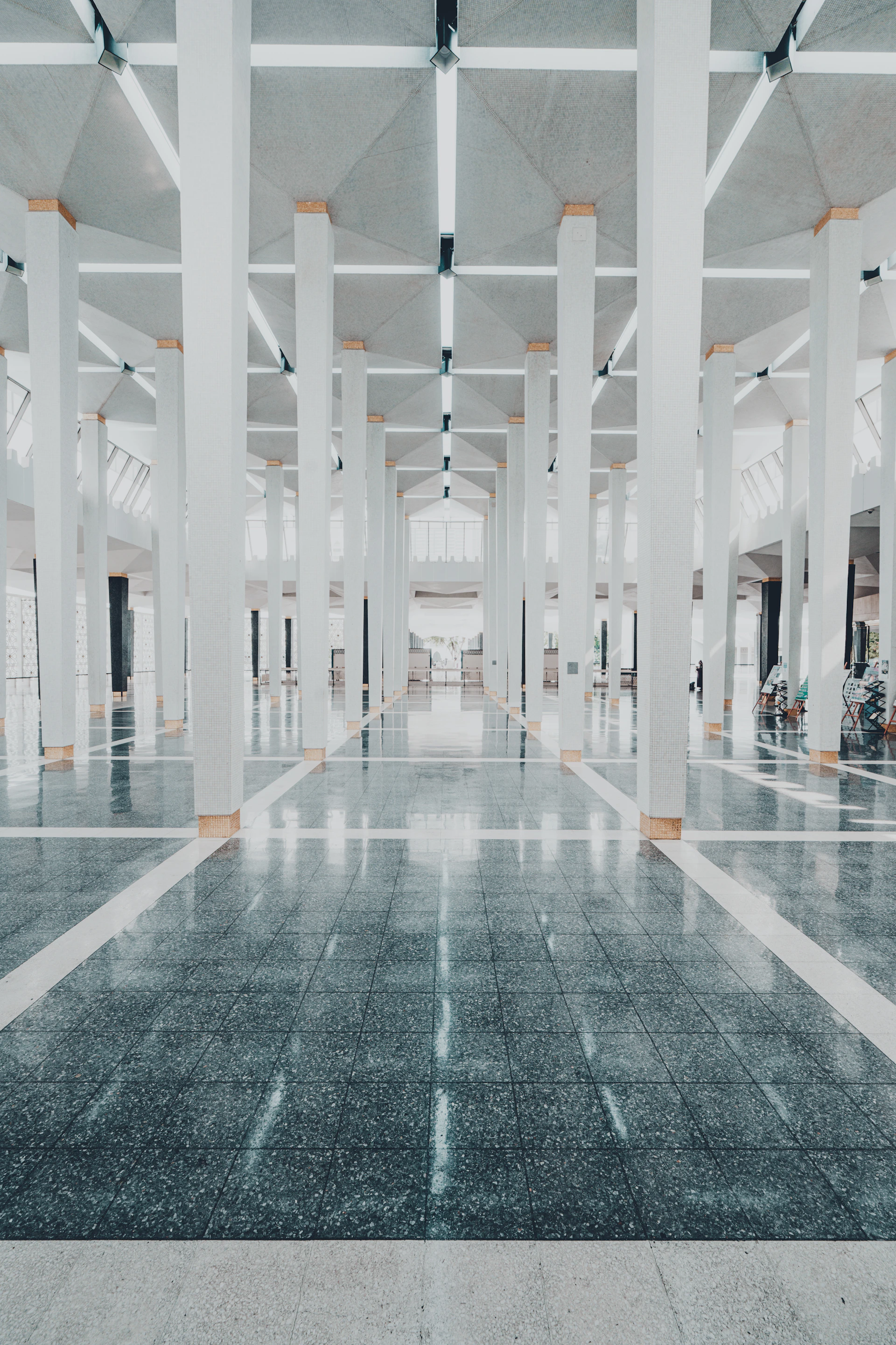 Empty modern hall with white pillars and reflective floor