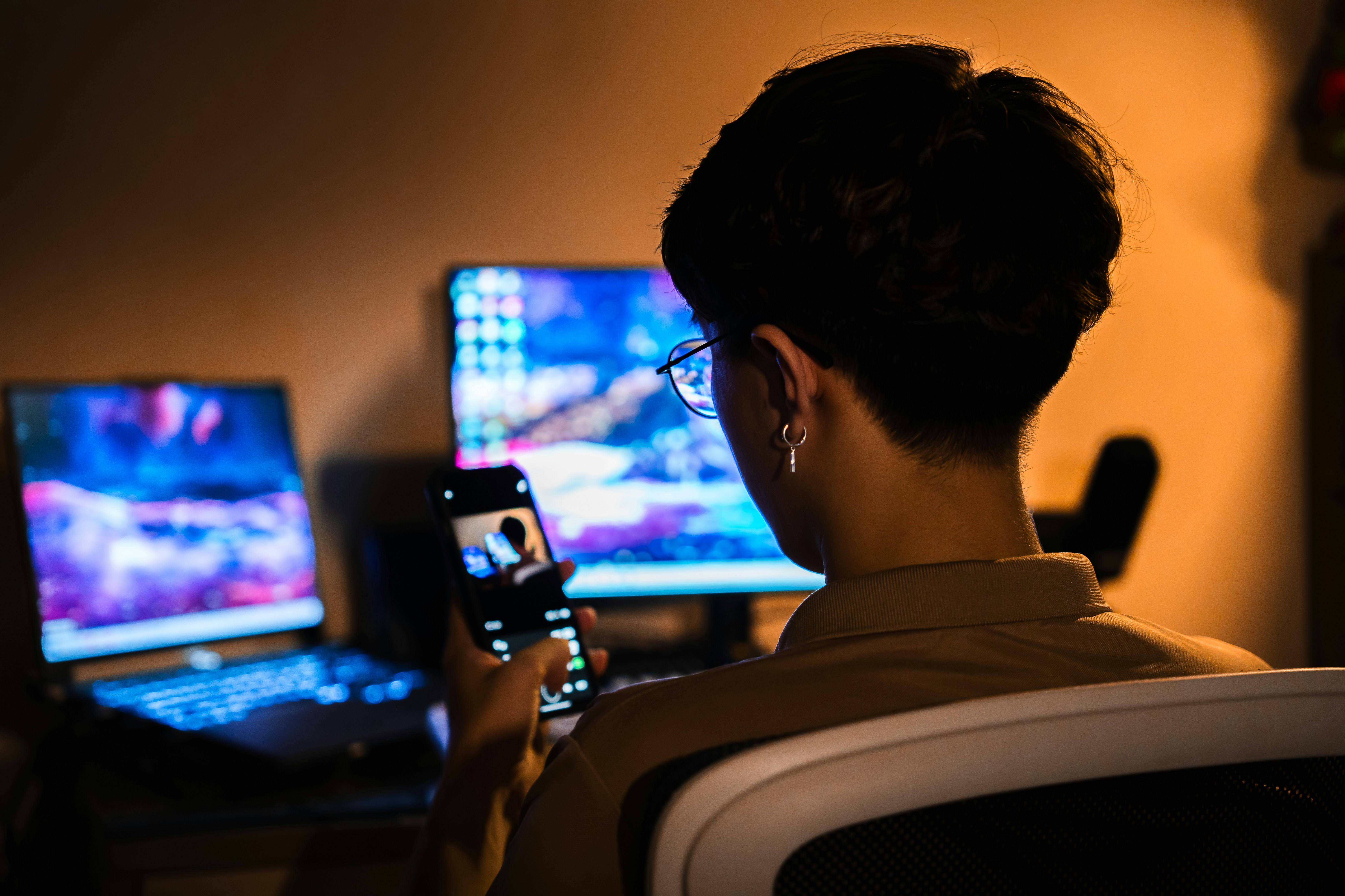 software engineer analyzing cloud server metrics on multiple computer screens