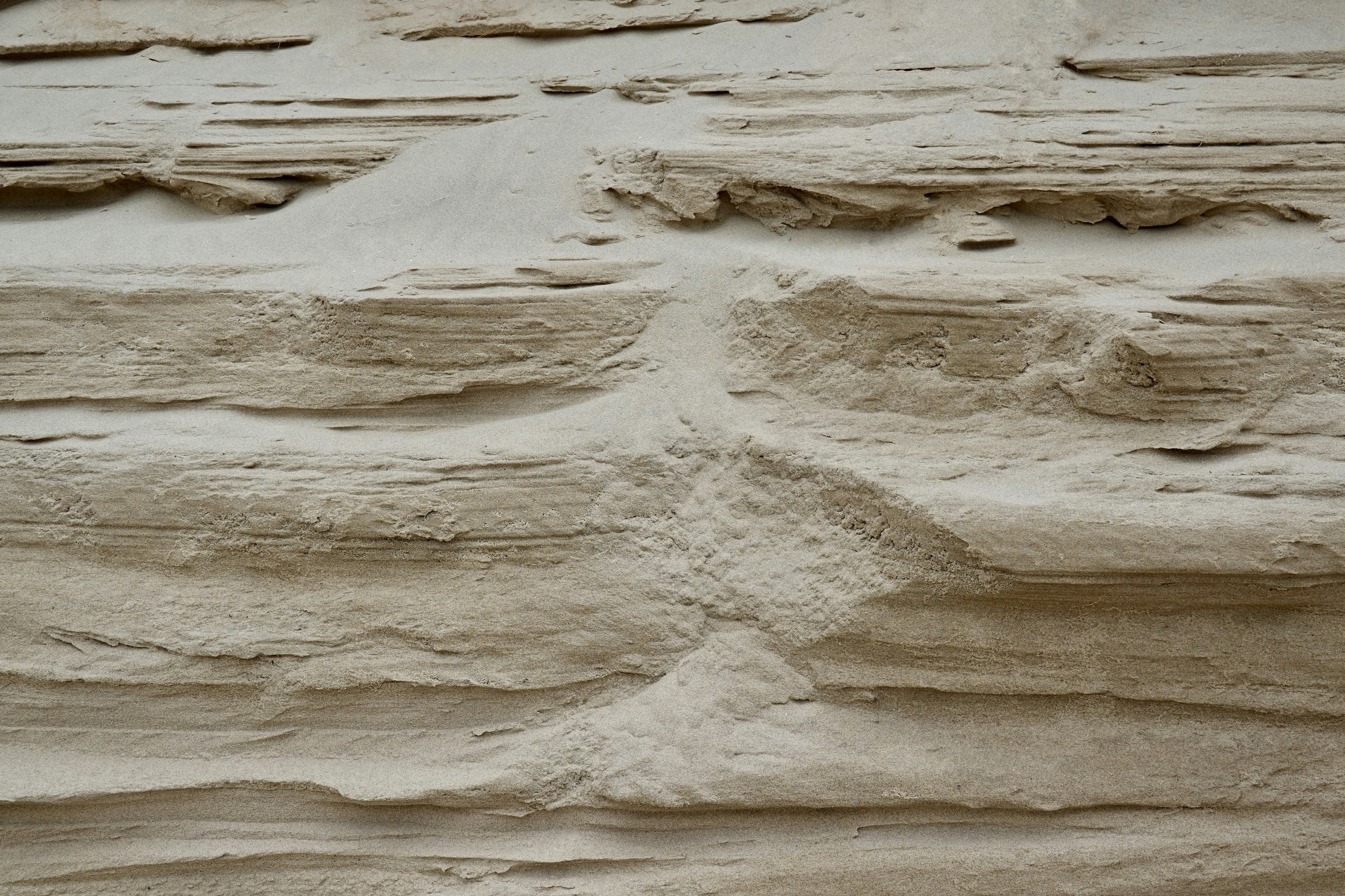 Strati di sabbia che mostrano stratificazione geologica e modelli di erosione.