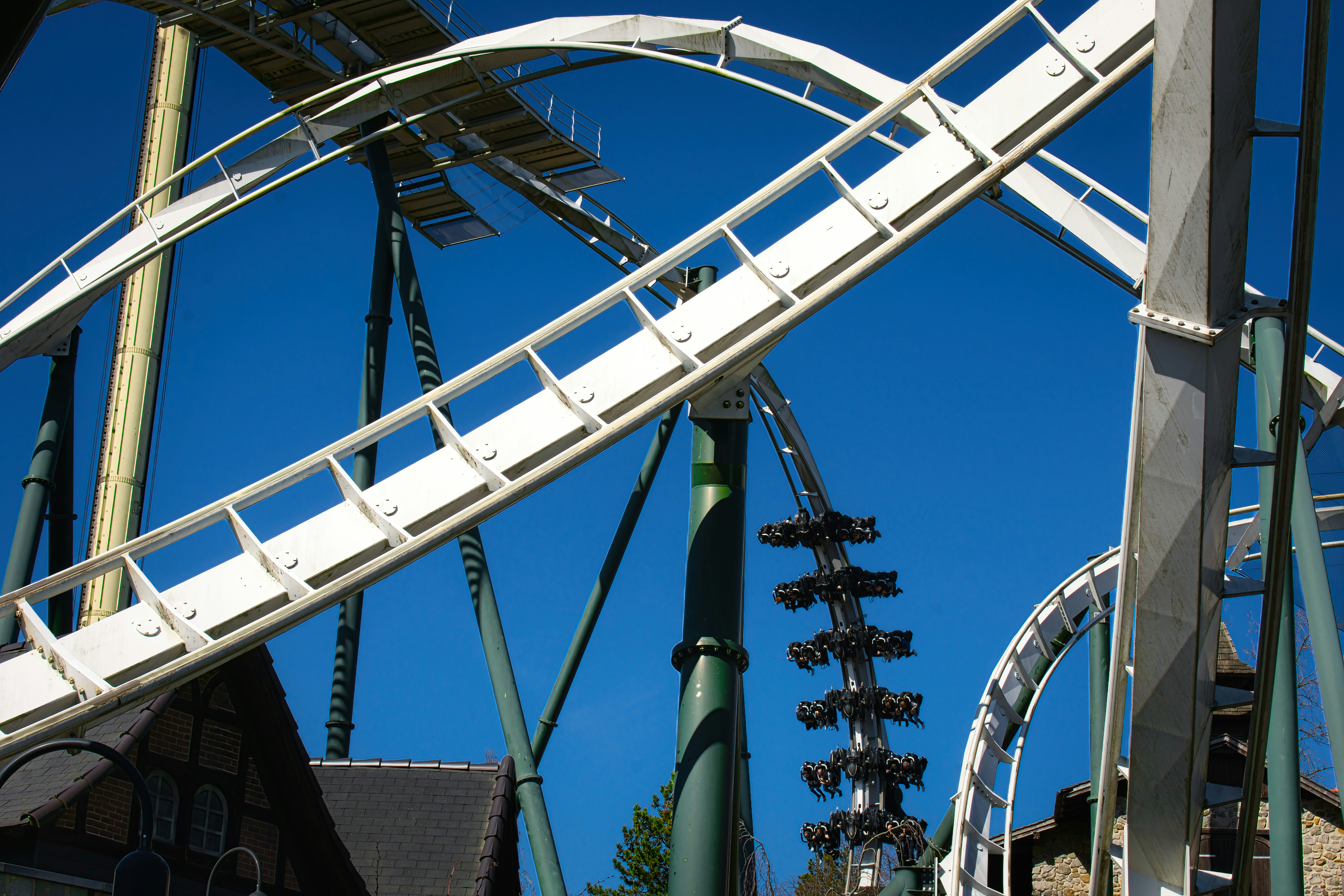 White roller coaster tracks against a clear blue sky.