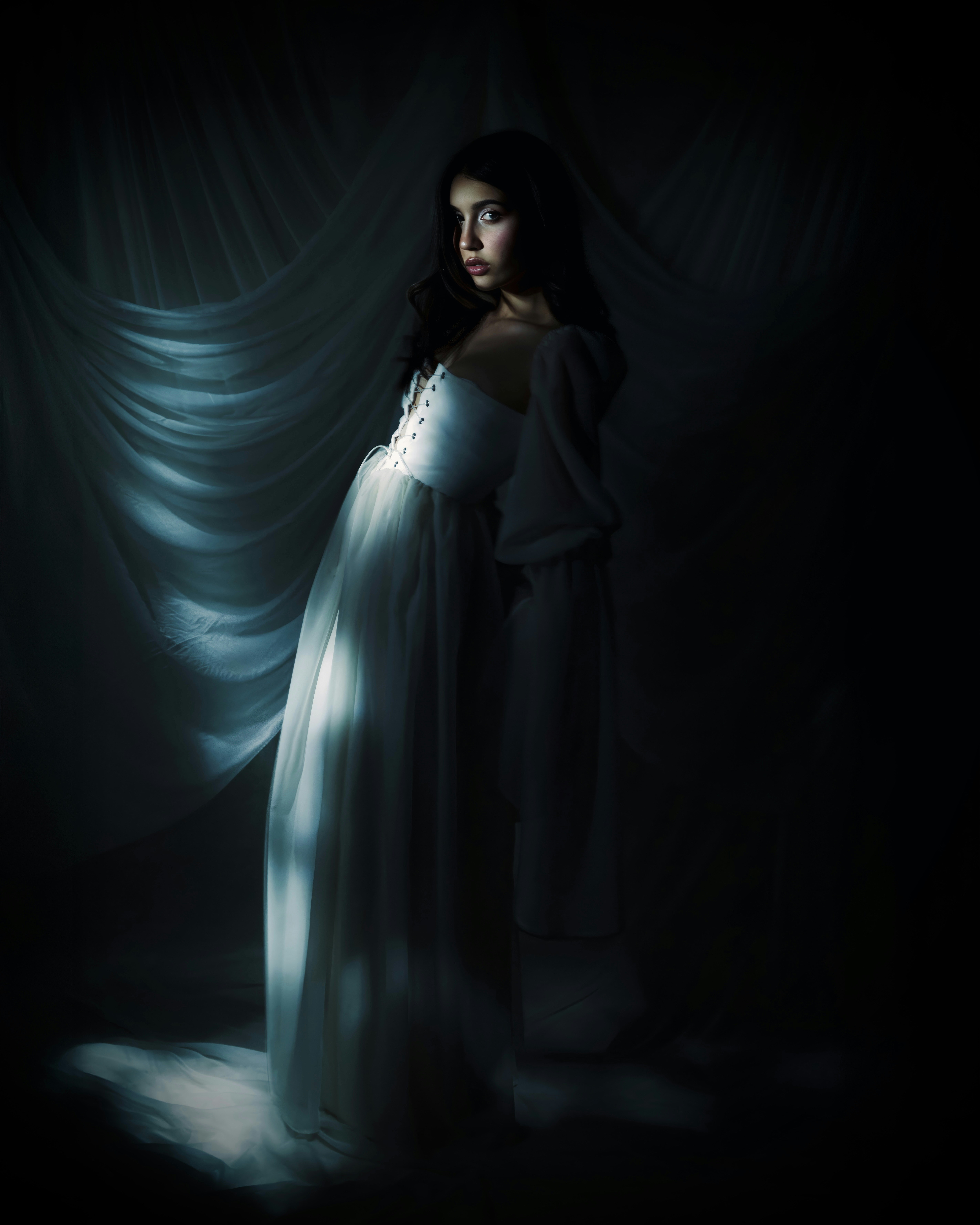 Model berkain sutra dalam studio gelap