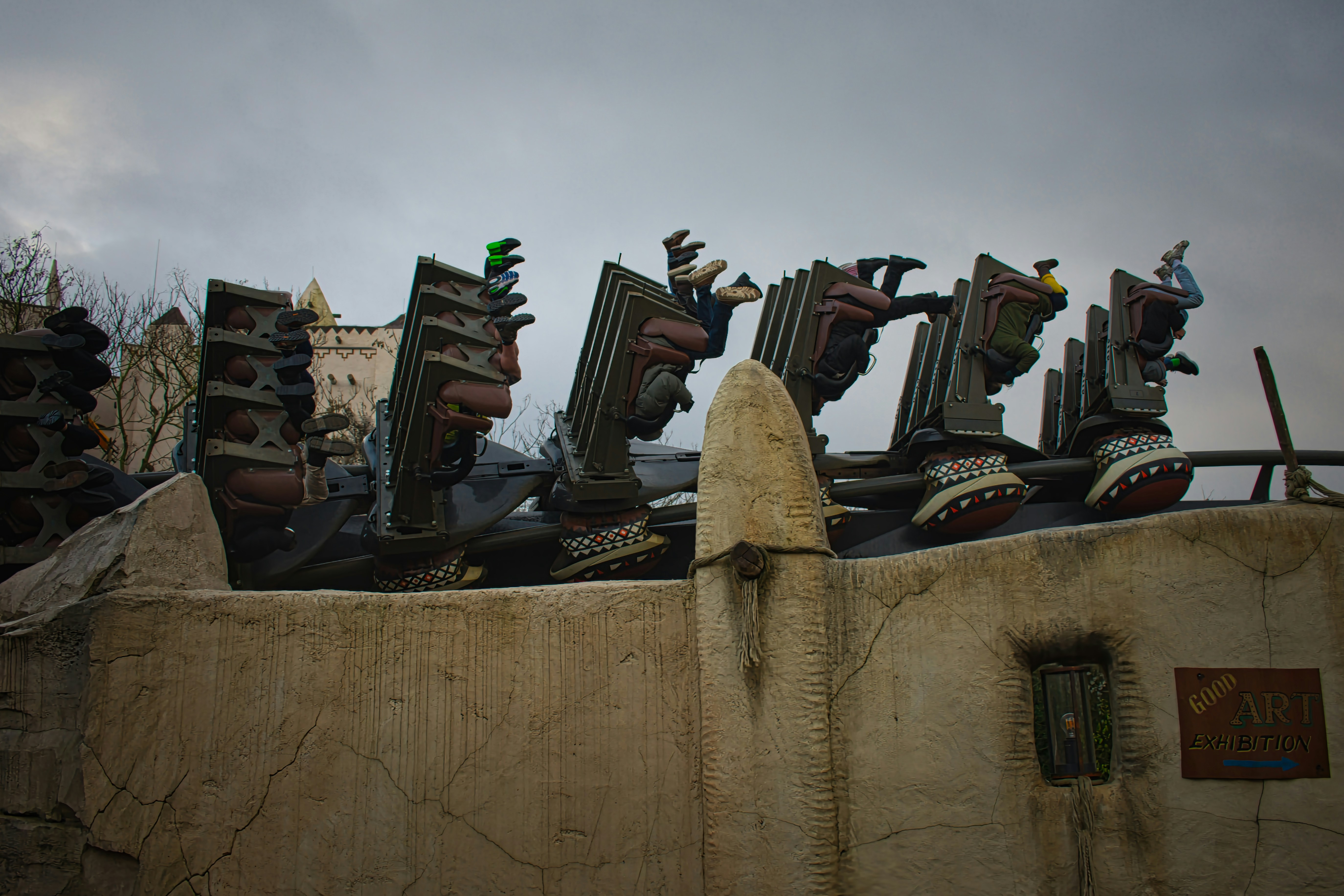 Roller coaster cars in an inversion on a weathered track.