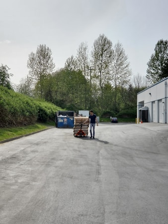A worker moving pallets outside a small-bay industrial suite, the type of local tenant Southwest Bay is designed to serve