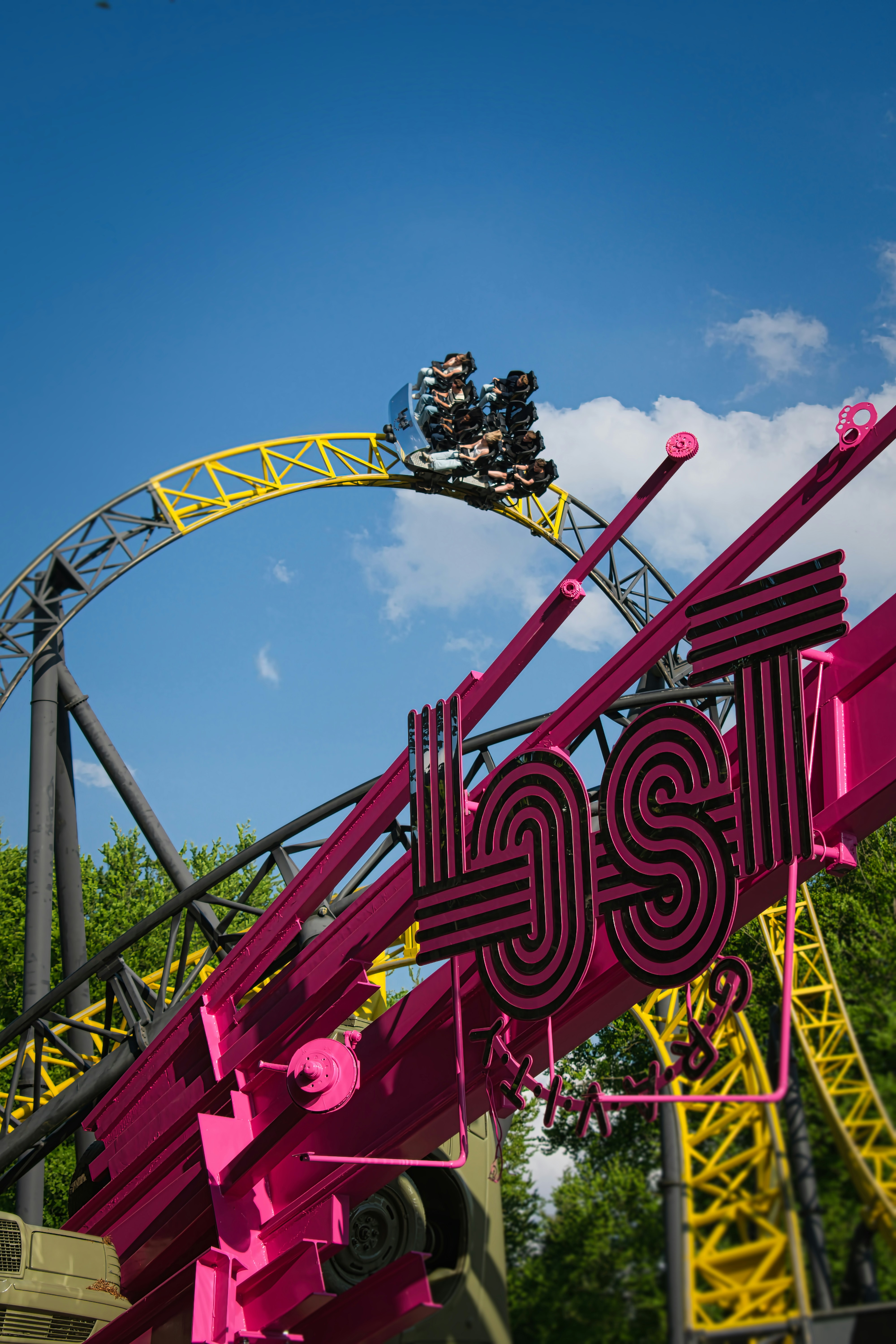Roller coaster loop with riders and a pink 'lost' sign.