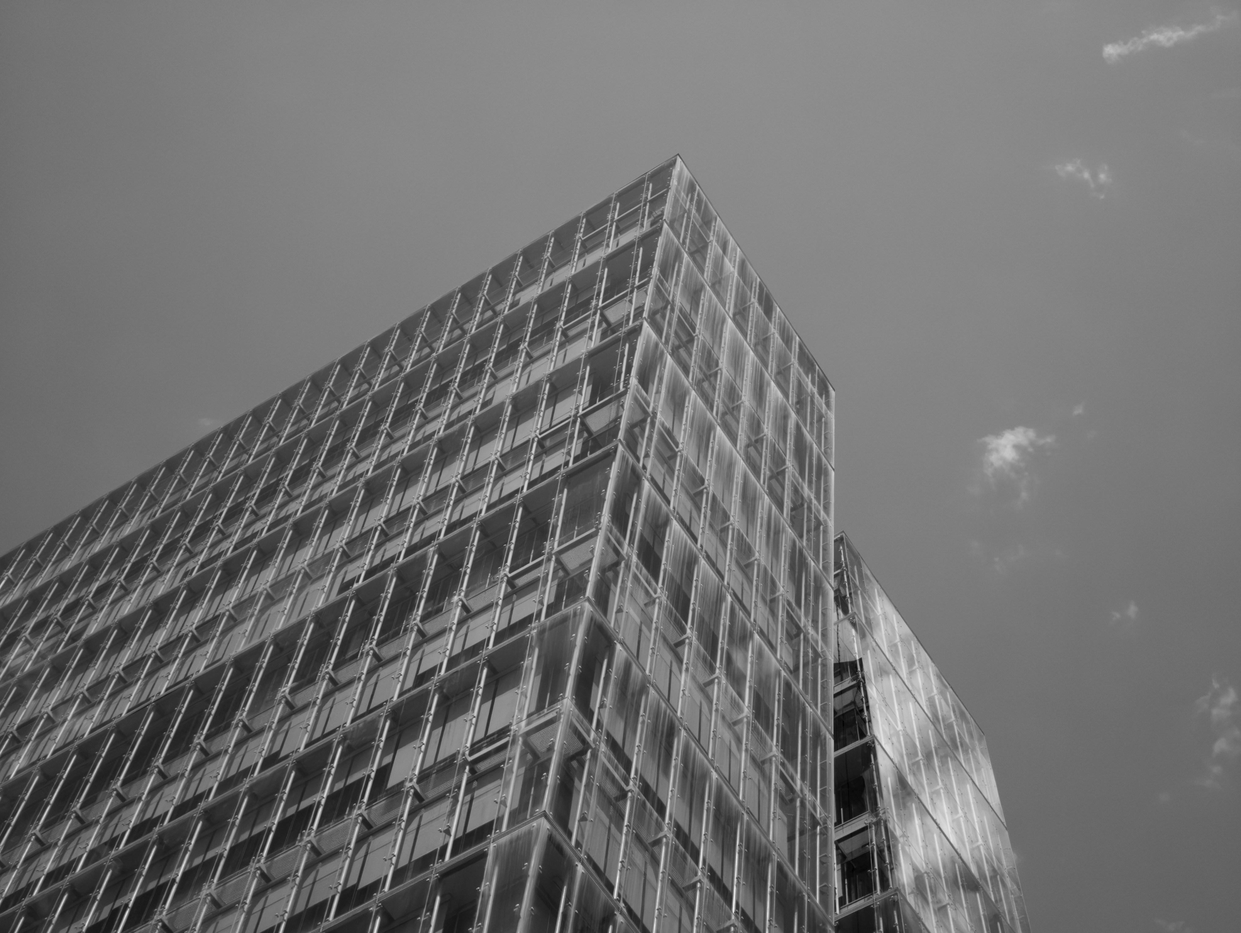 Modern building with many windows against a cloudy sky.