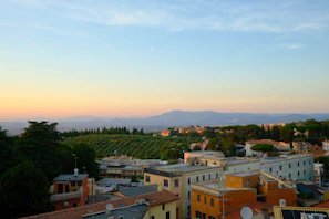 Cityscape with distant mountains under a beautiful sunset sky.