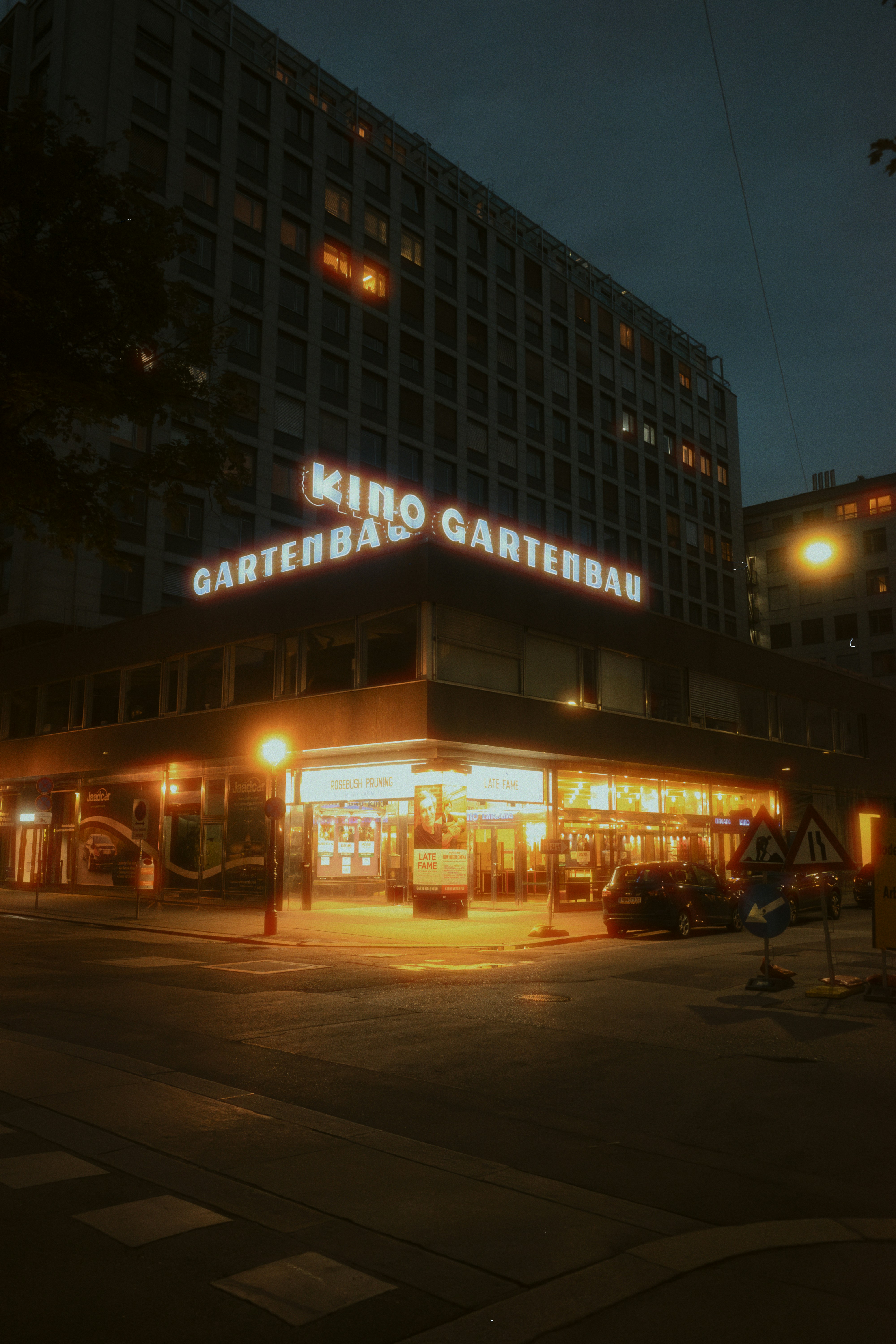 Illuminated kino gartenbau cinema building at night.