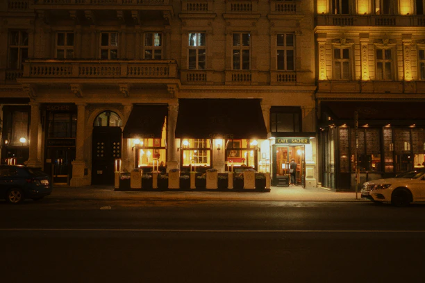 Night view of a city street with an illuminated restaurant.