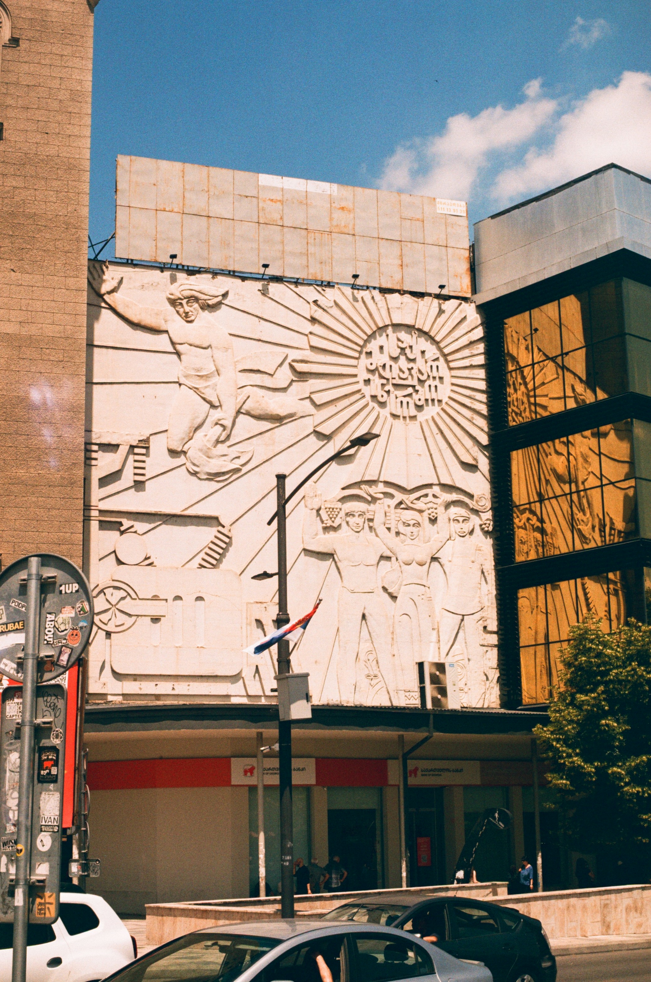 Detailed bas-relief artwork on a building with reflective golden windows