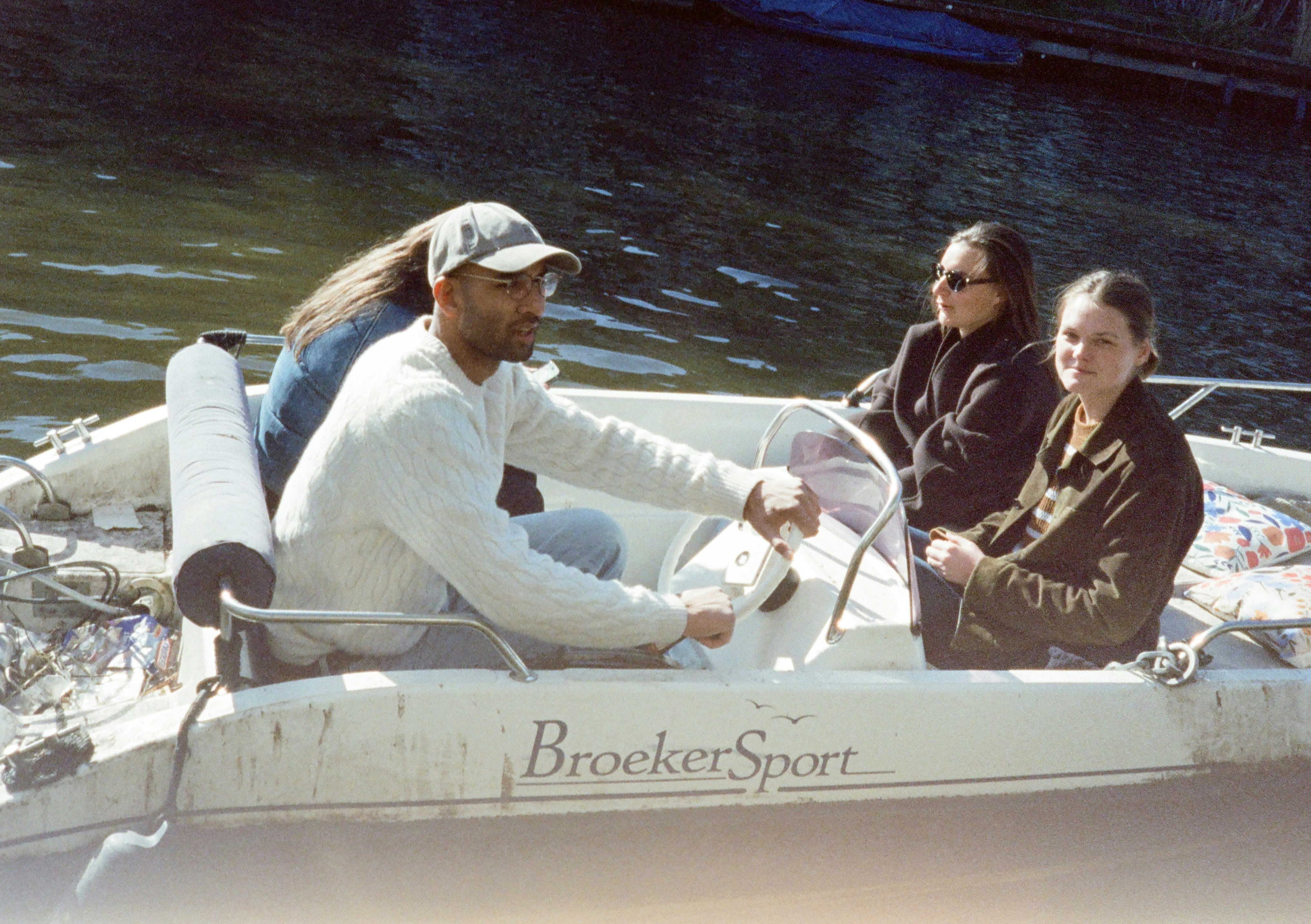A man drives a broekersport boat with two women passengers
