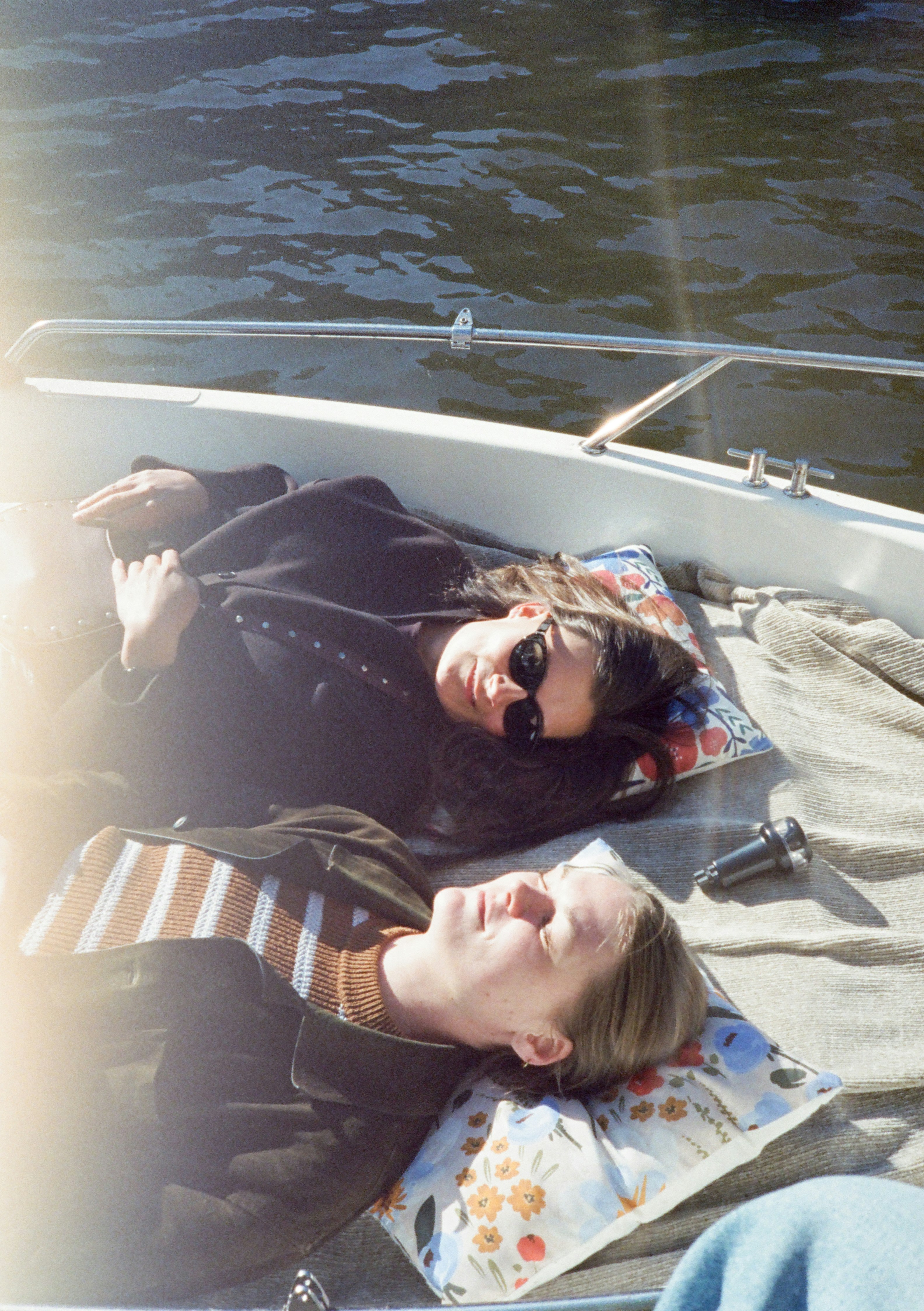 Photo of Two people relaxing on a boat under sunlight. by Kristina Bekher