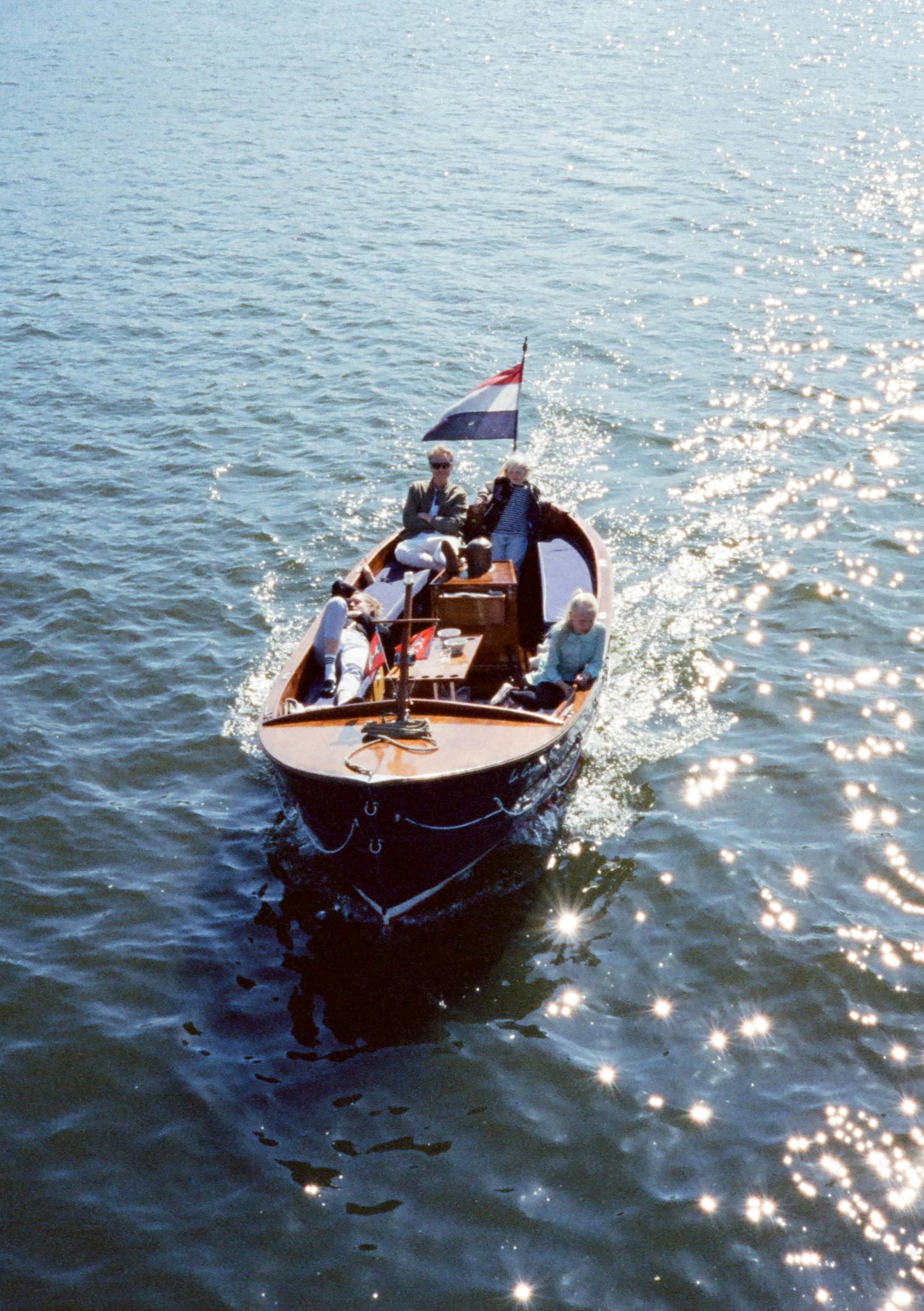 A small boat with people cruises on sparkling water