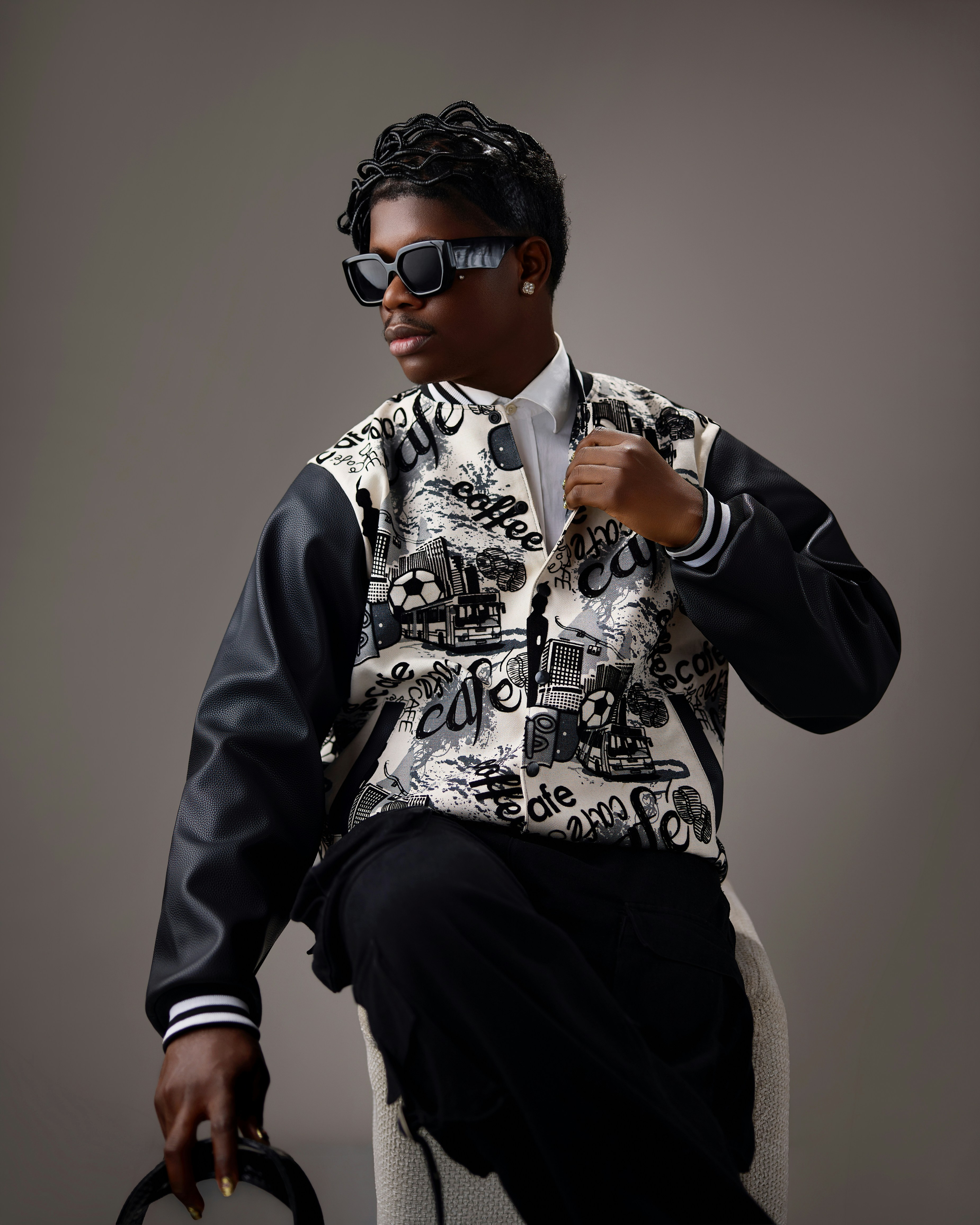 A stylish person in a patterned jacket and sunglasses