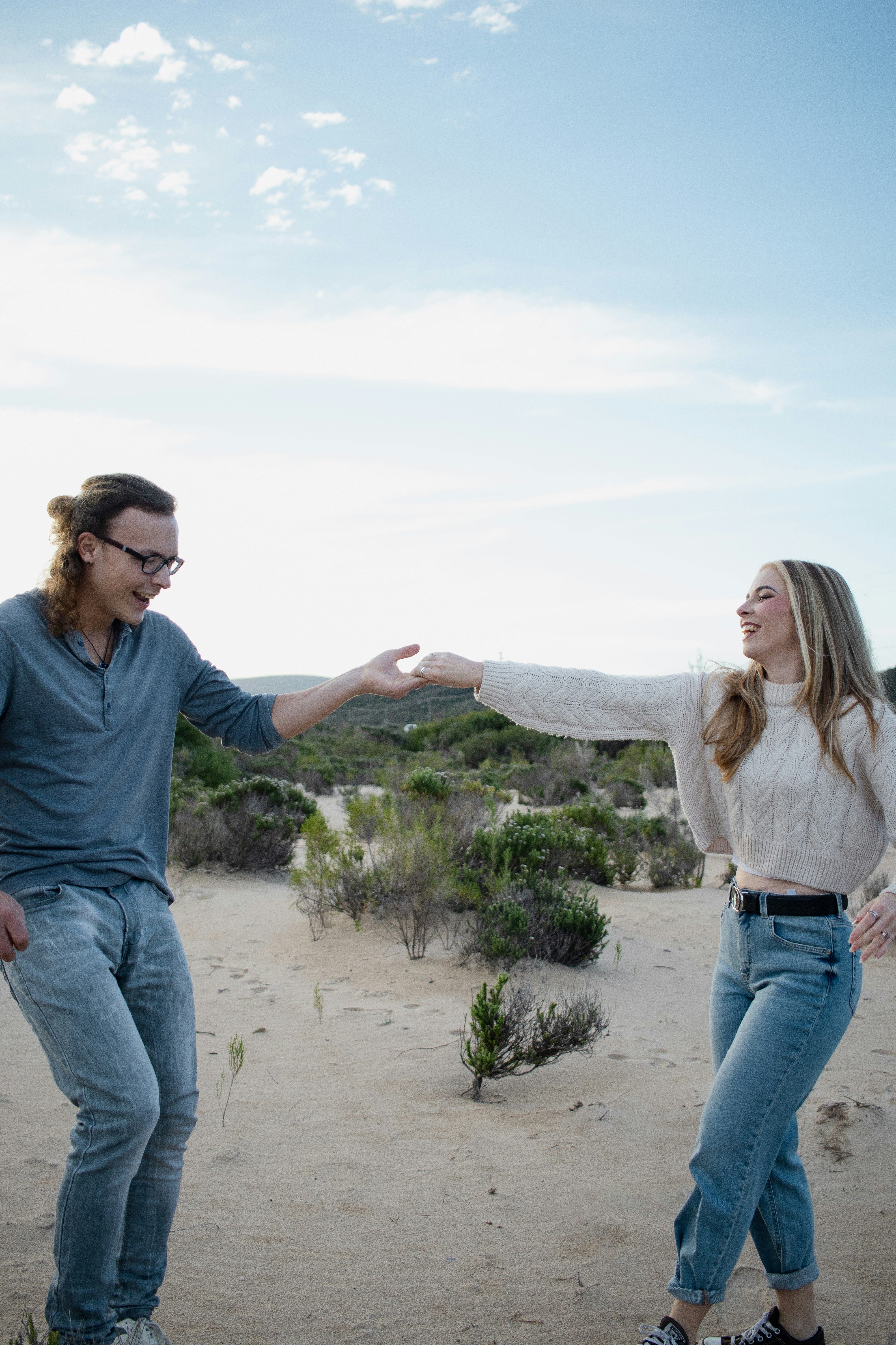 Happy couple holding hands outdoors in a desert landscape