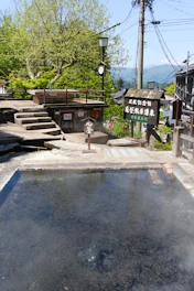 Outdoor hot spring with steam in a traditional japanese setting