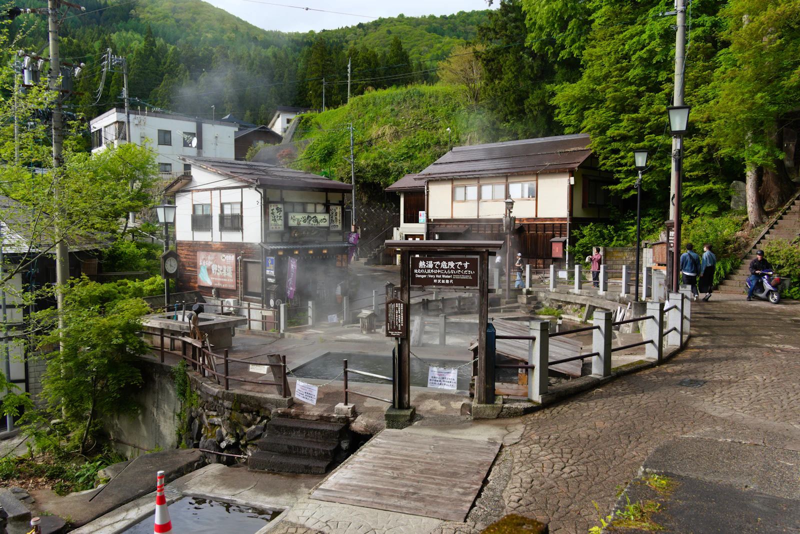 Steam rising over a hot spring village nestled in the mountains