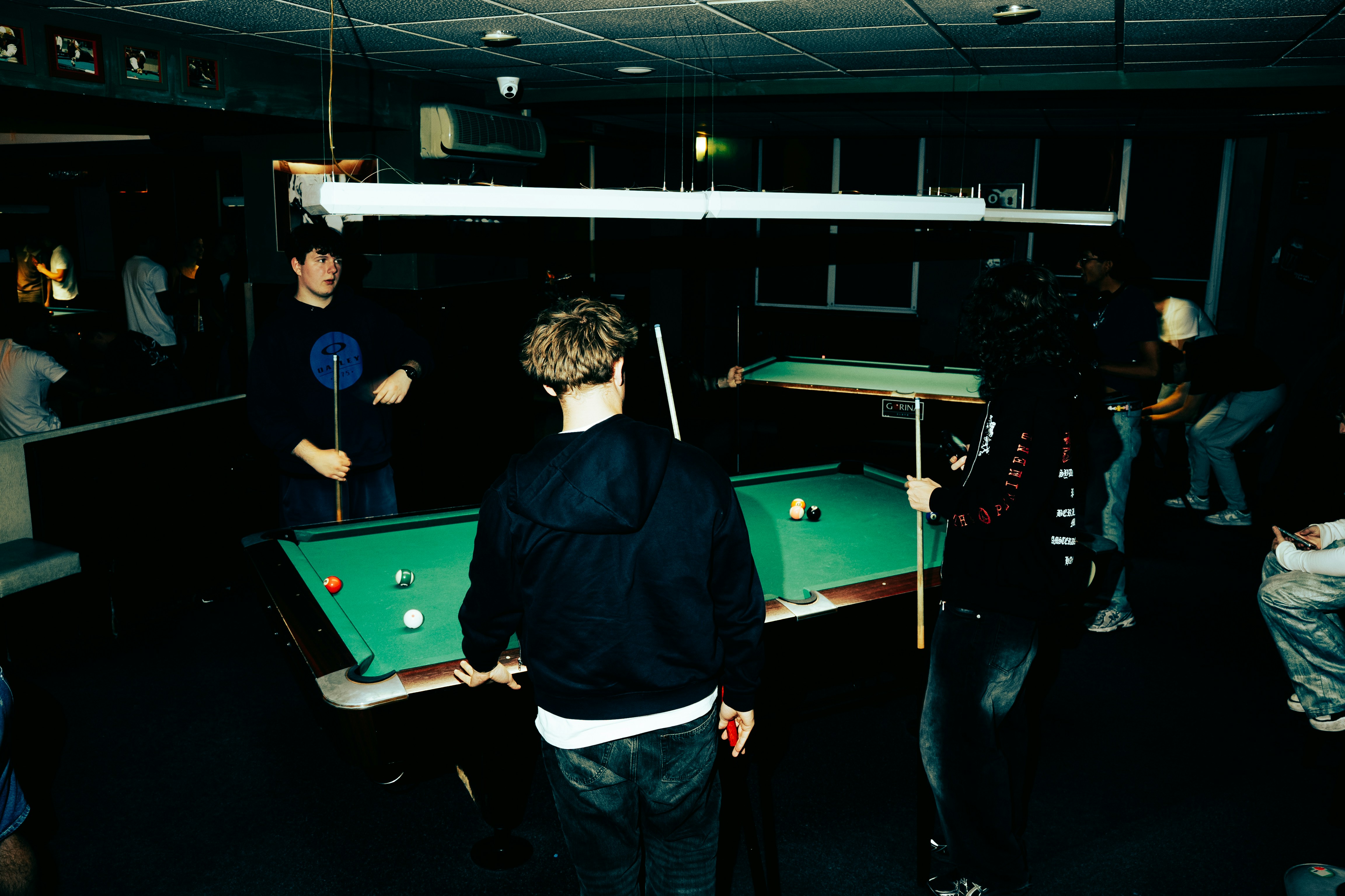 Leute, die Billard in einem schwach beleuchteten Raum spielen