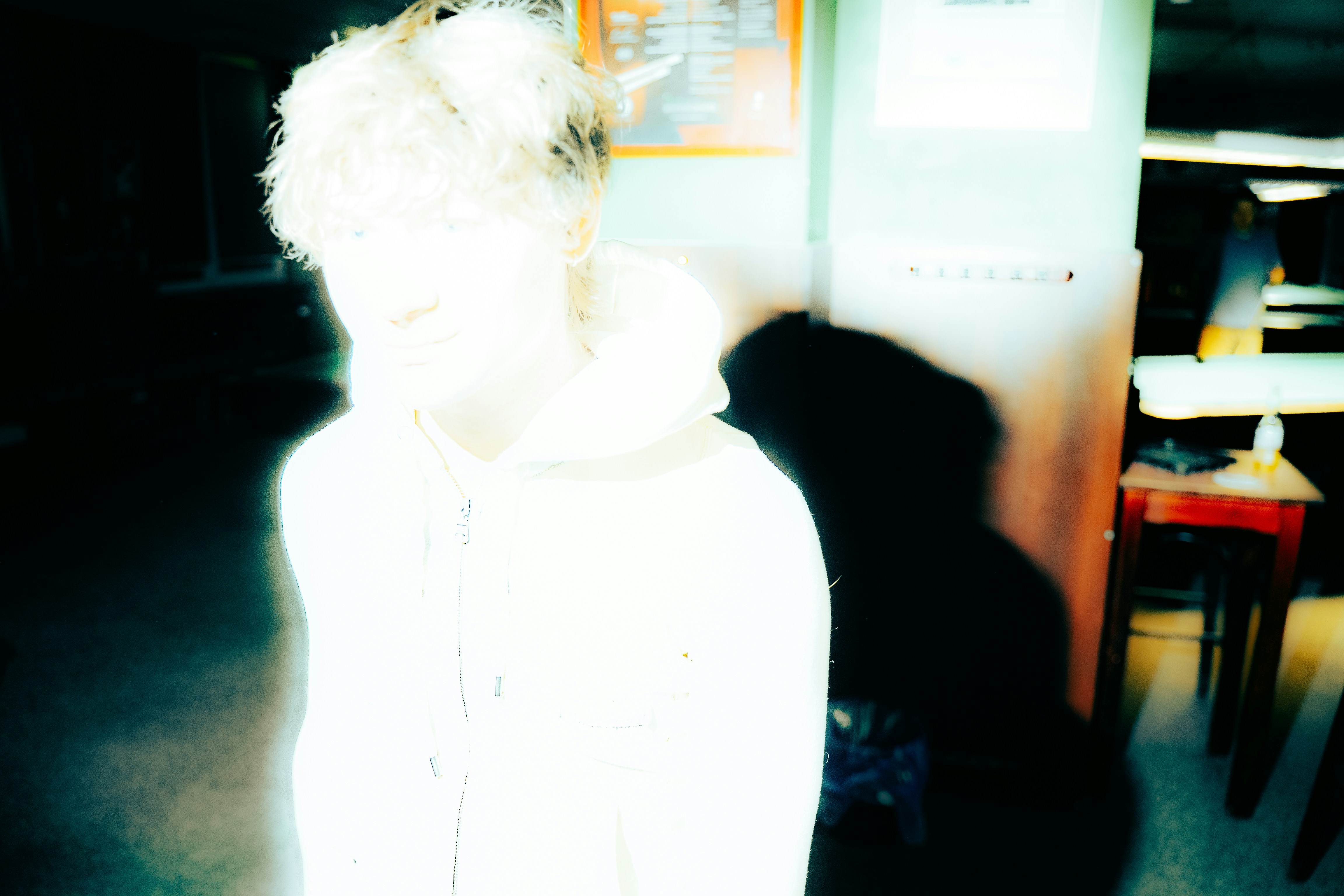Leuchtende Person mit lockigem Haar in einem hellen Hoodie