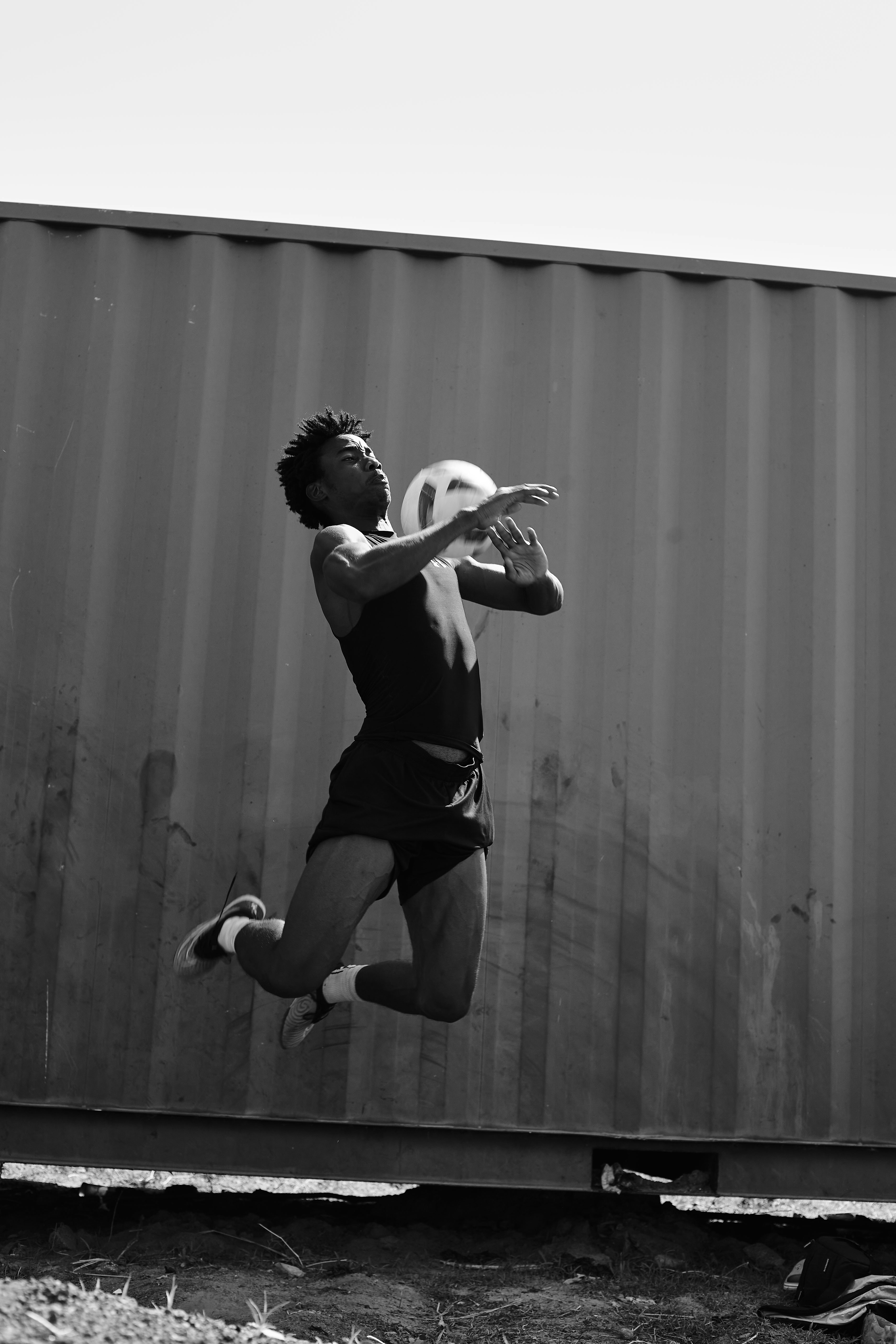 An athlete leaps to catch a ball outdoors