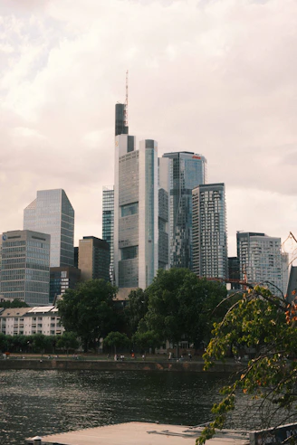 Modern skyscrapers, a river, and green trees in a city
