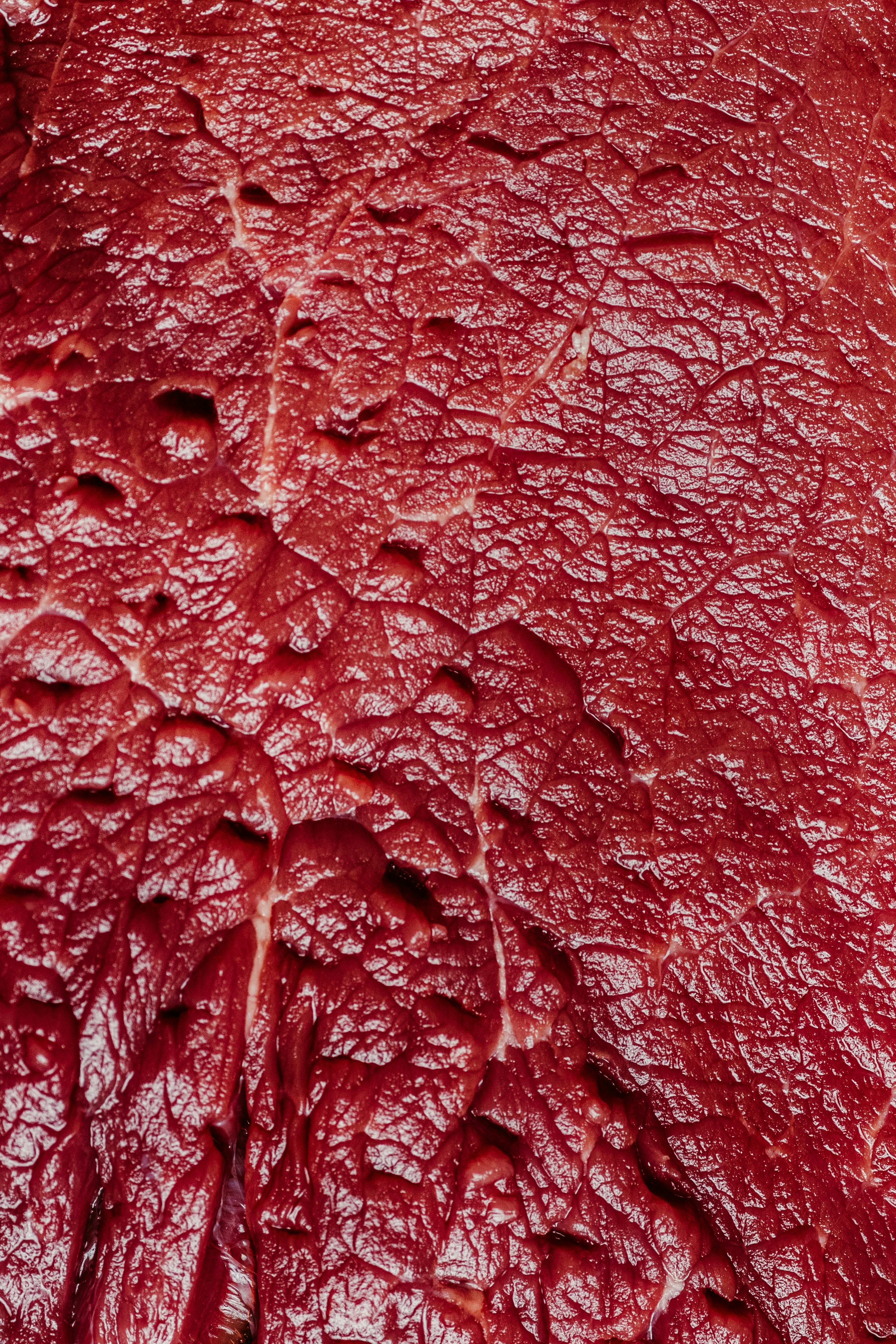Textured surface of raw red meat.