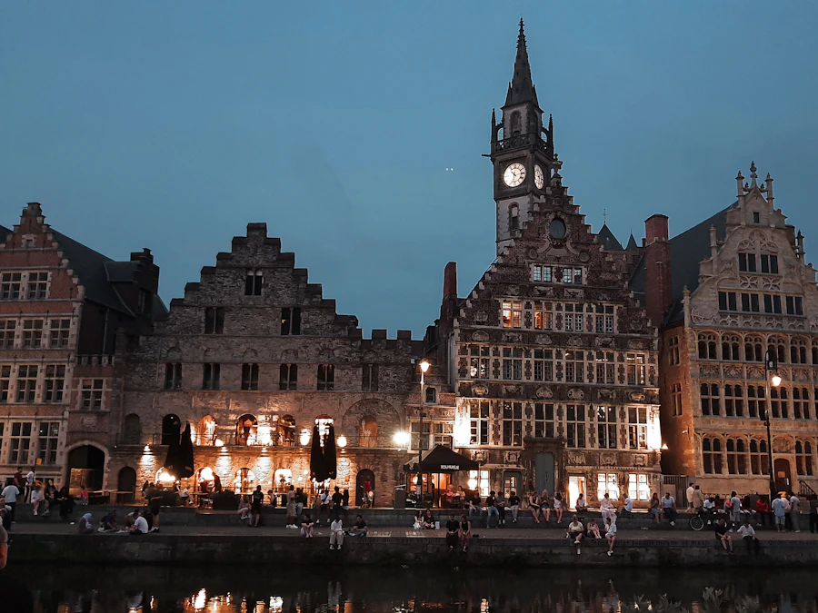 Façades historiques illuminées et beffroi au bord de l'eau à Gand