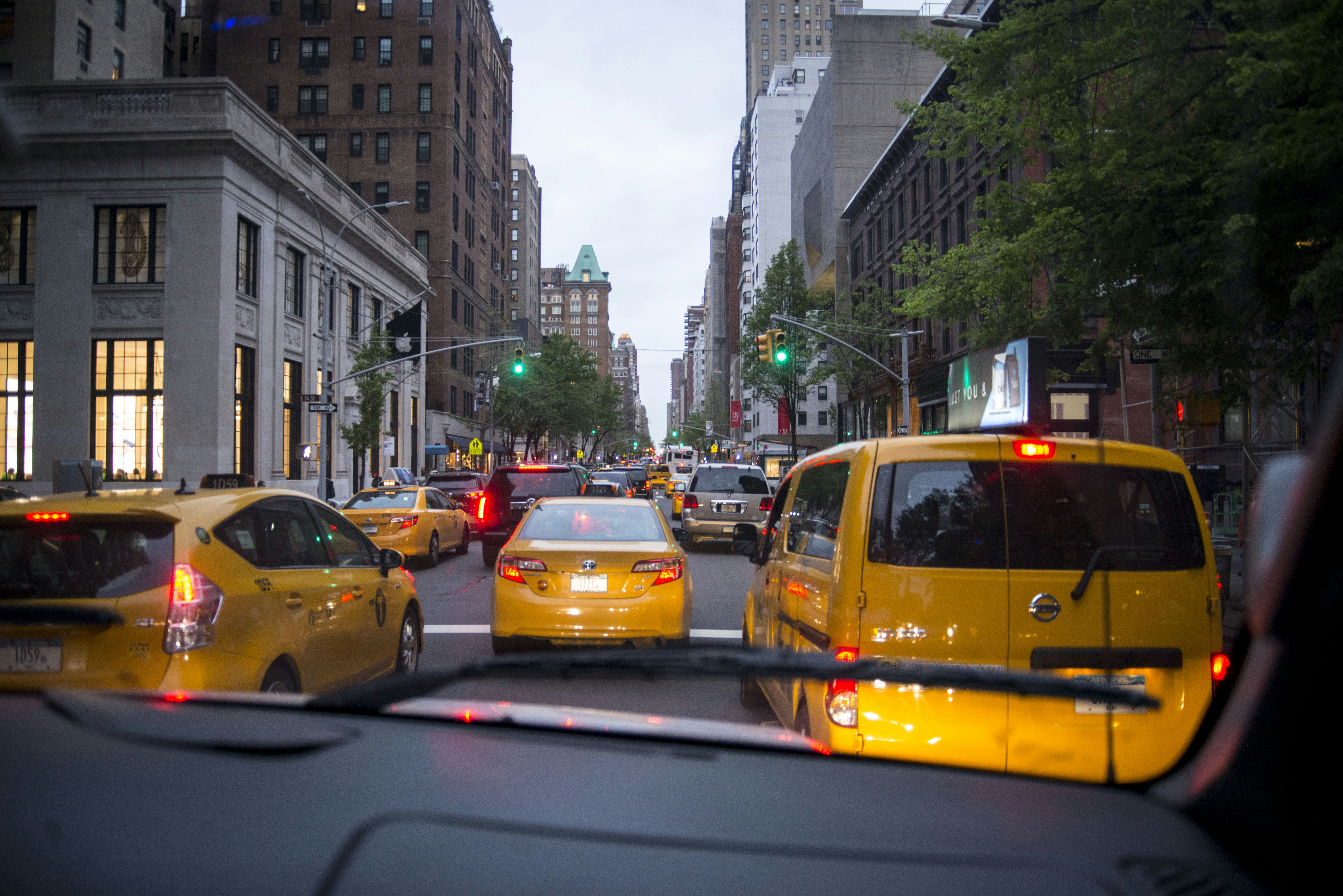Yellow taxis on a busy city street with tall buildings
