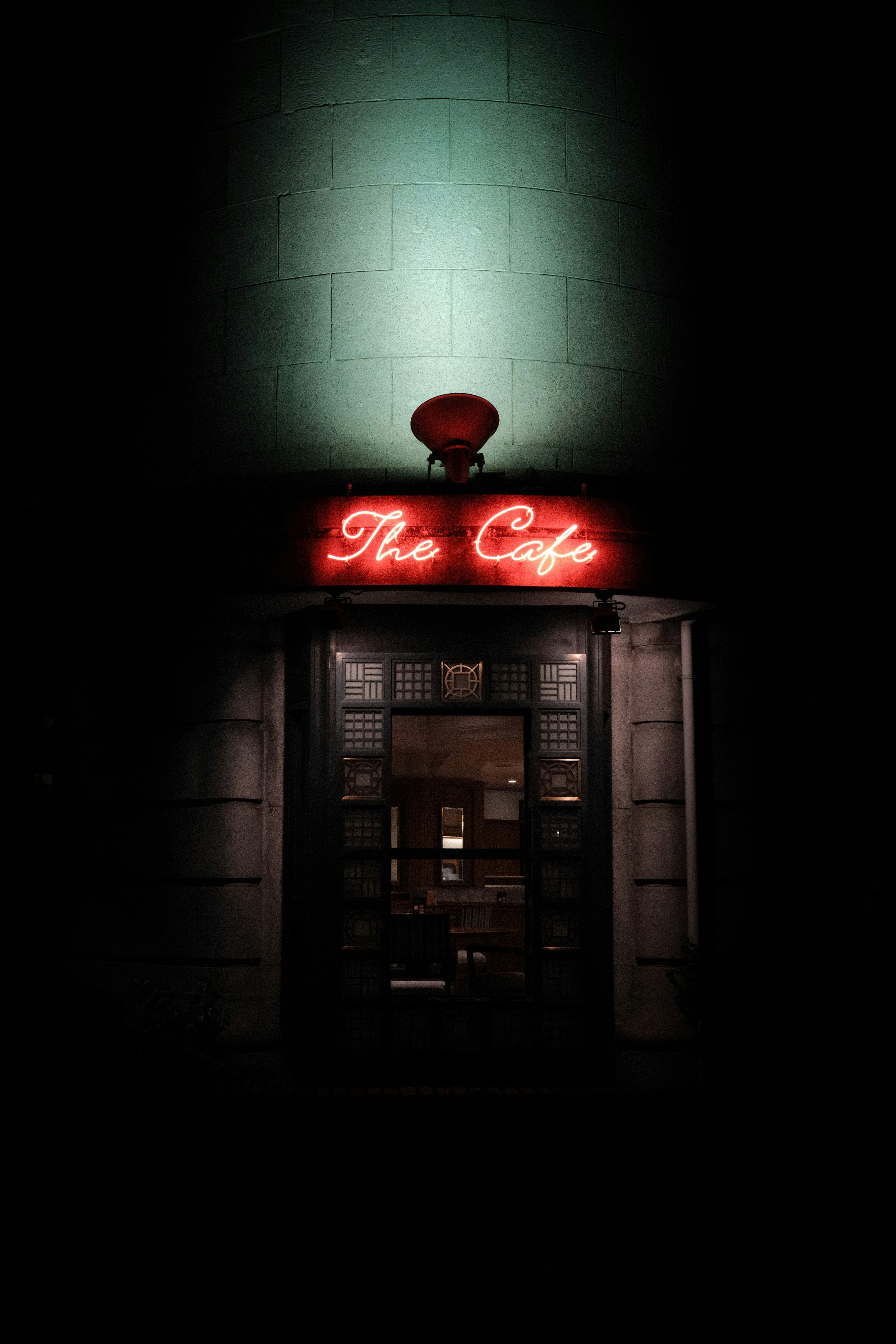 The cafe neon sign illuminates dark yokohama entrance
