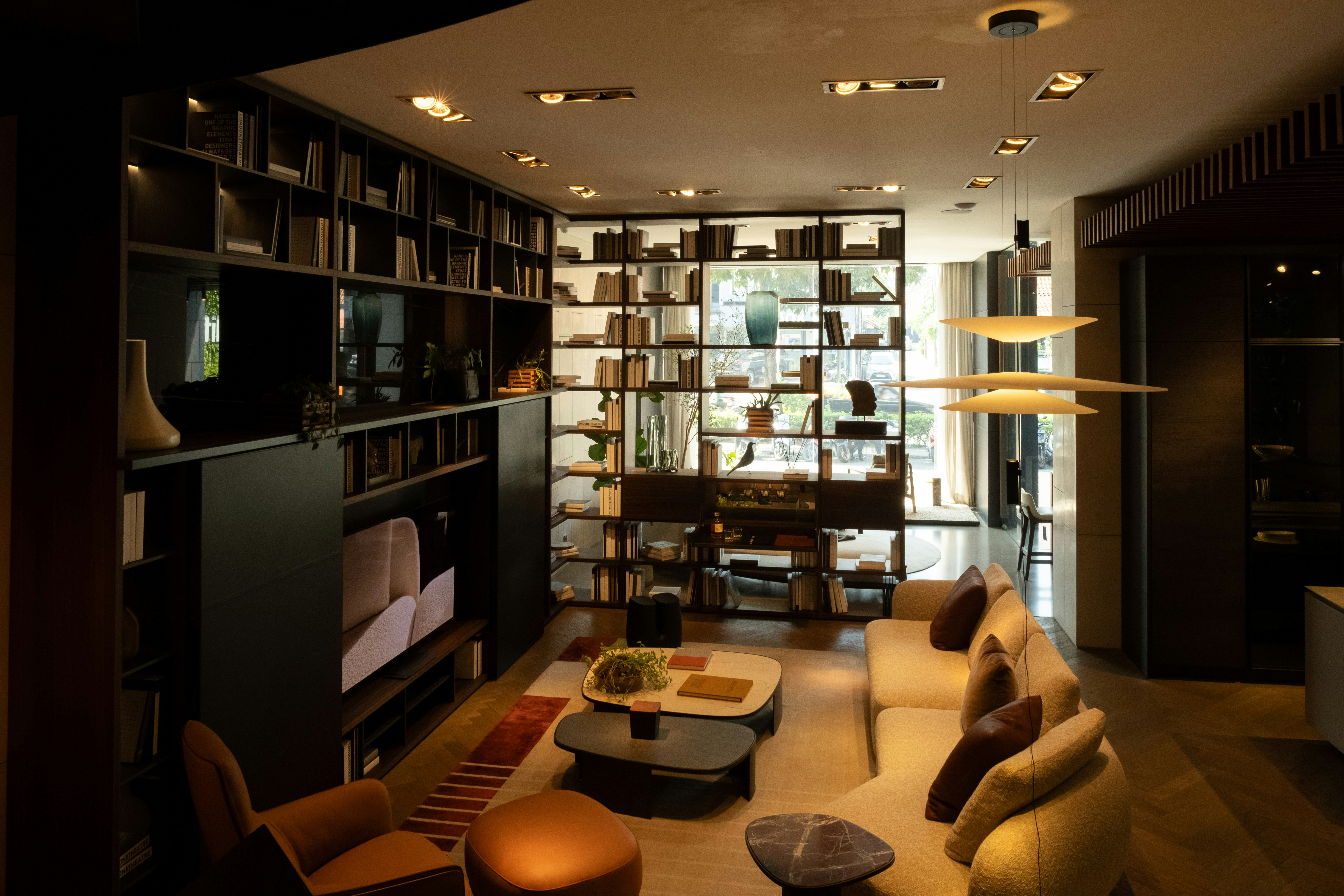 Modern living room with bookshelves, sofa, and coffee tables.