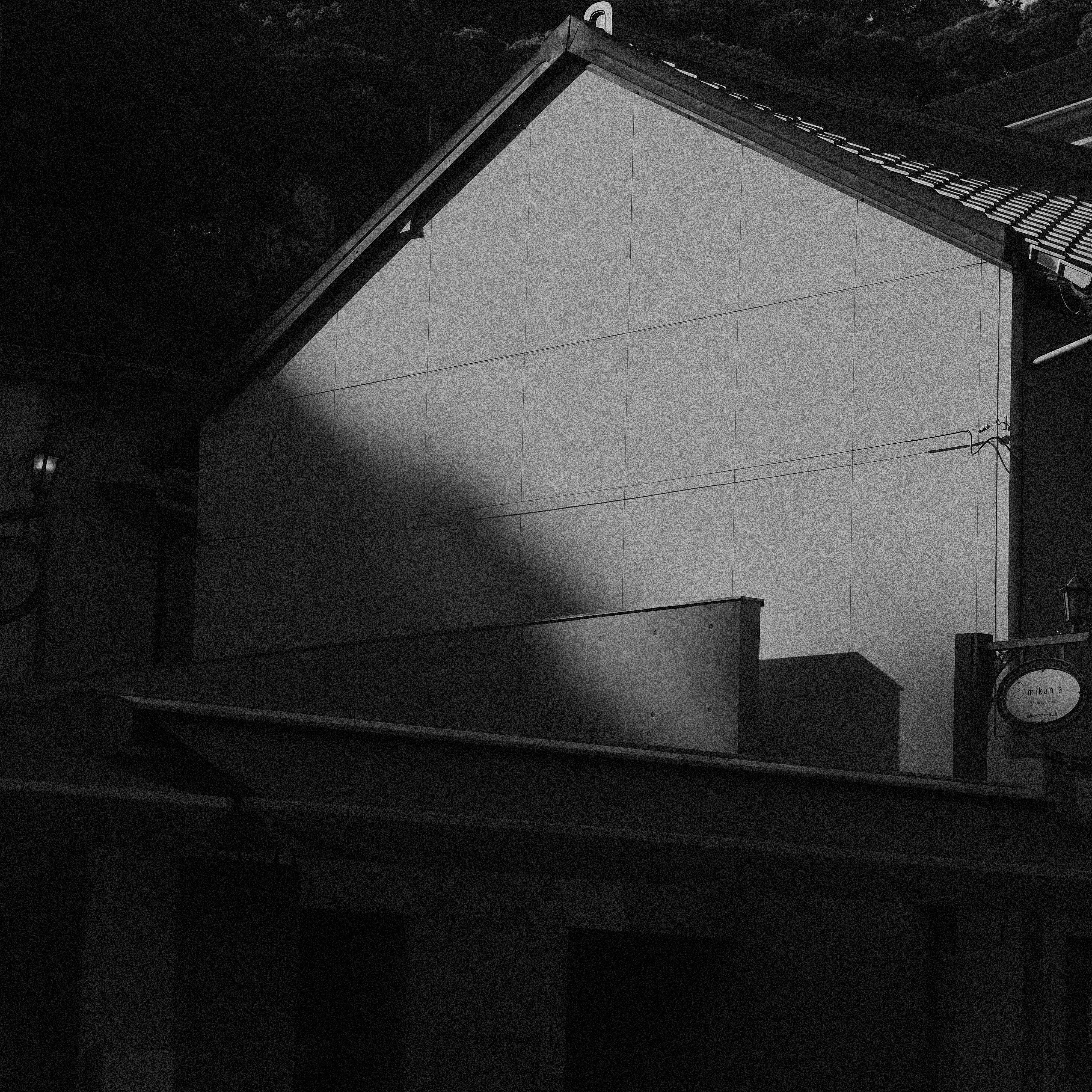 Graustufengebäude mit einem markanten diagonalen Schatten.