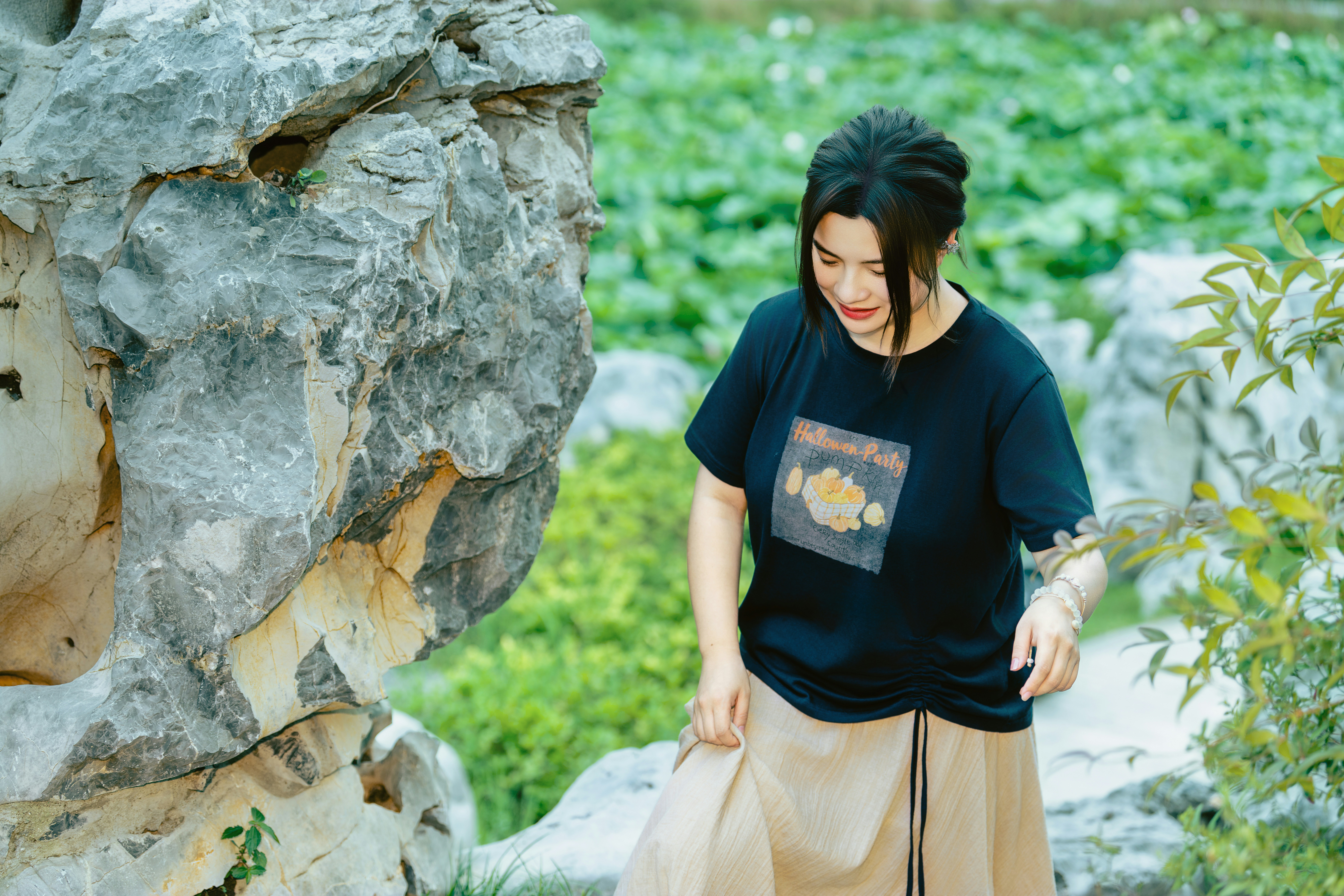 Woman walking past large rocks outdoors
