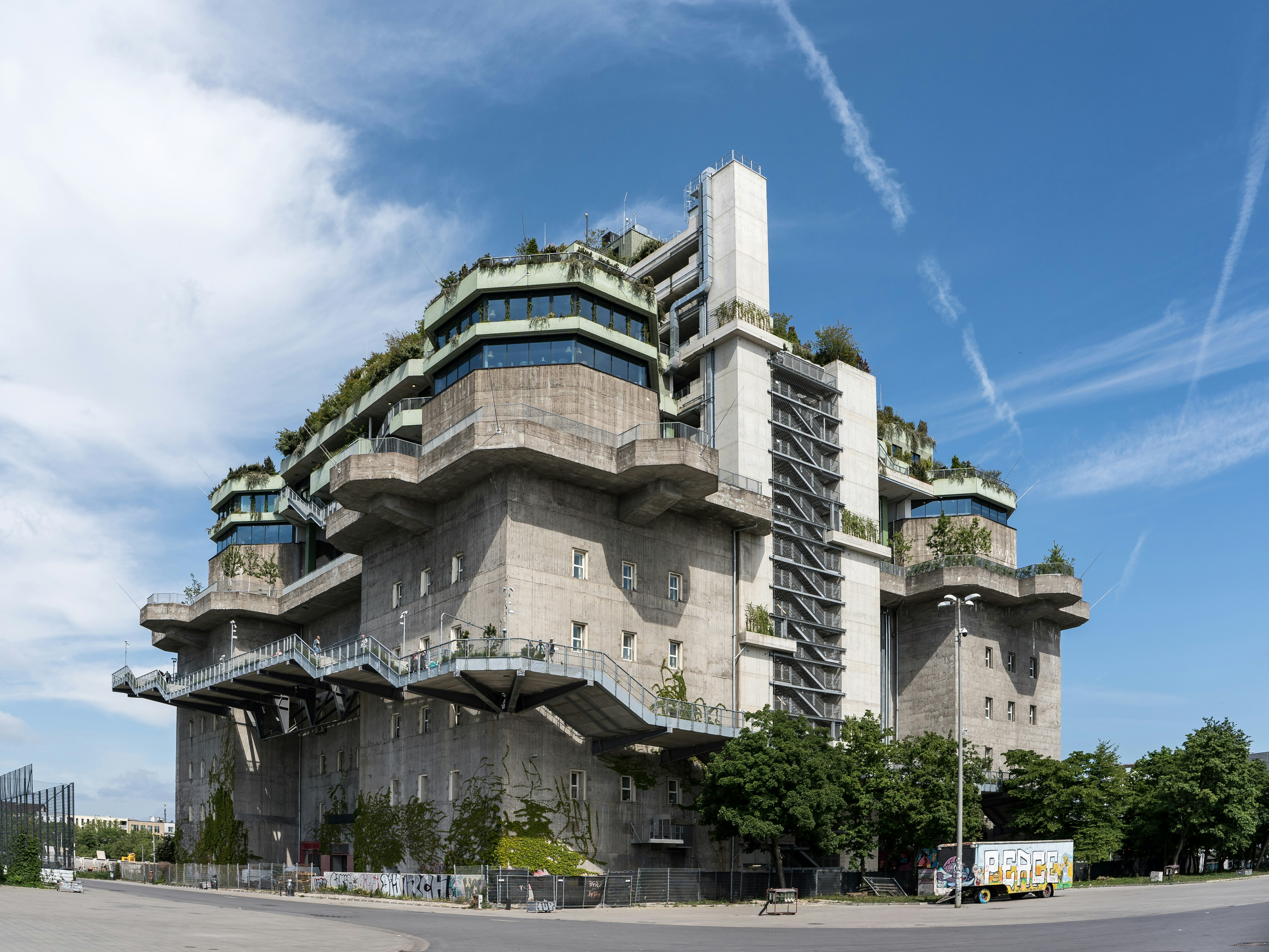 Brutalist concrete building with rooftop gardens and exterior staircases.