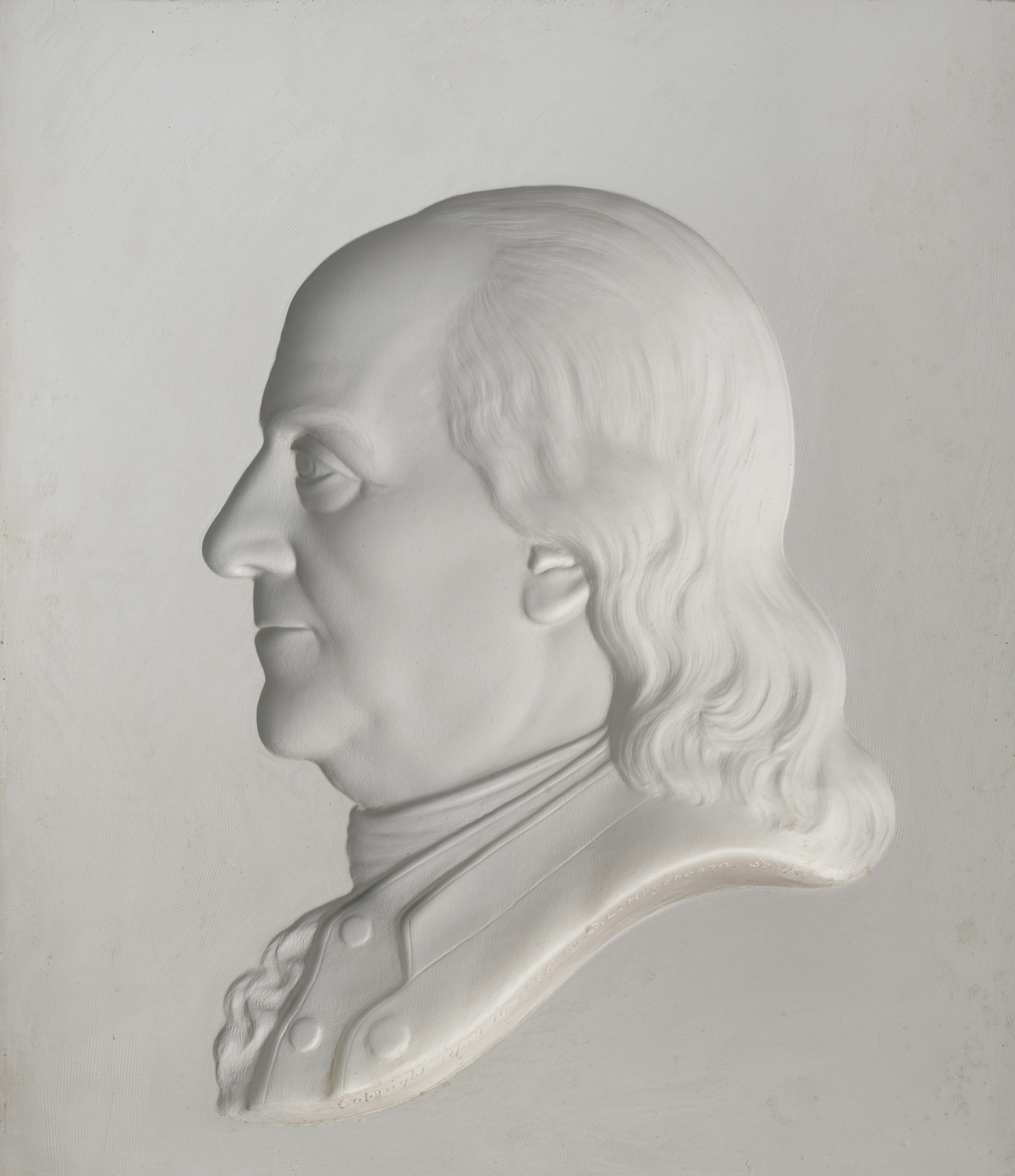 White relief sculpture of benjamin franklin's head in profile