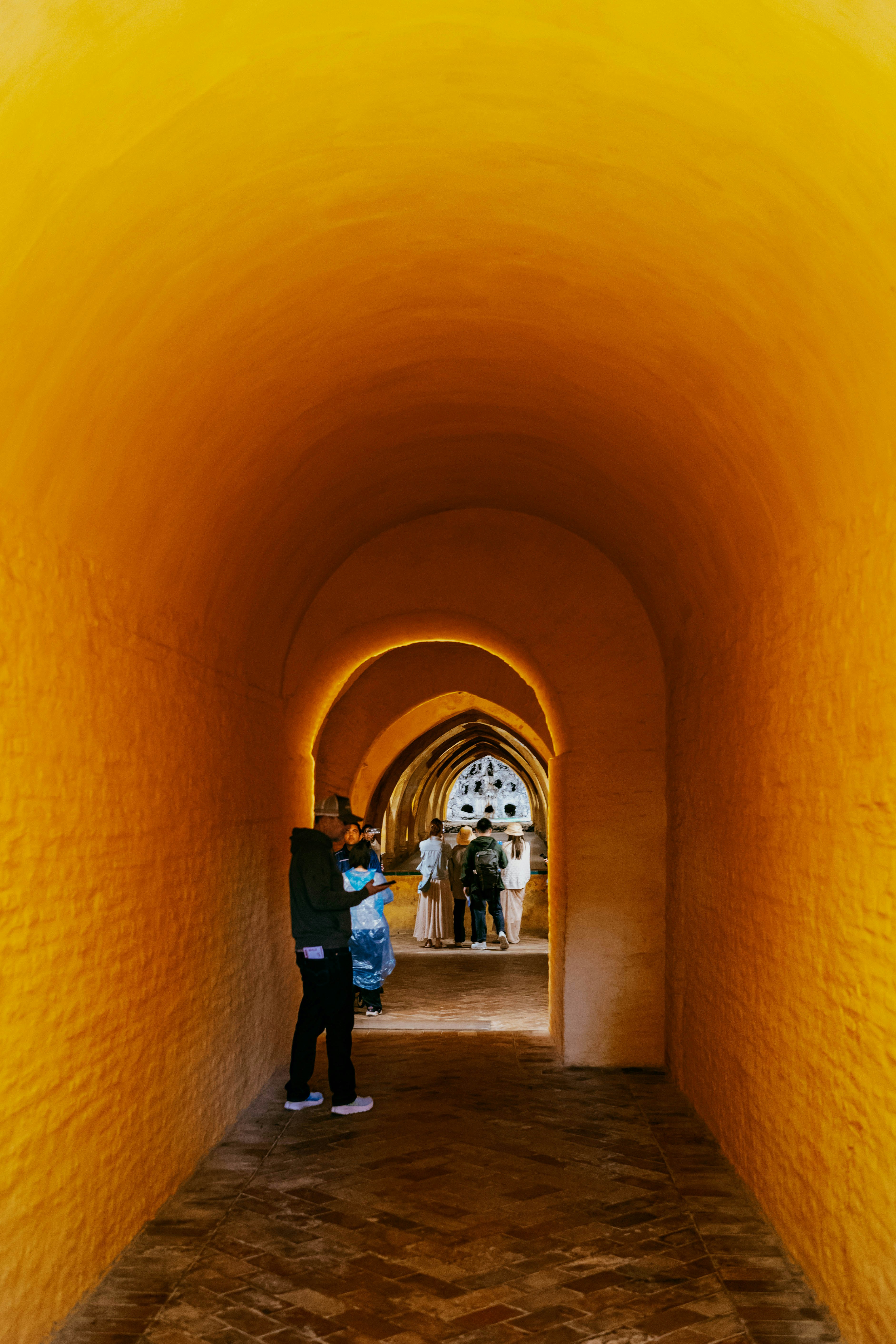 Ein leuchtend orangefarbener Bogentunnel mit Menschen darin