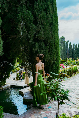 Elegant woman in green dress in a formal garden