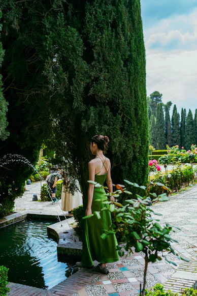 Elegant woman in green dress in a formal garden