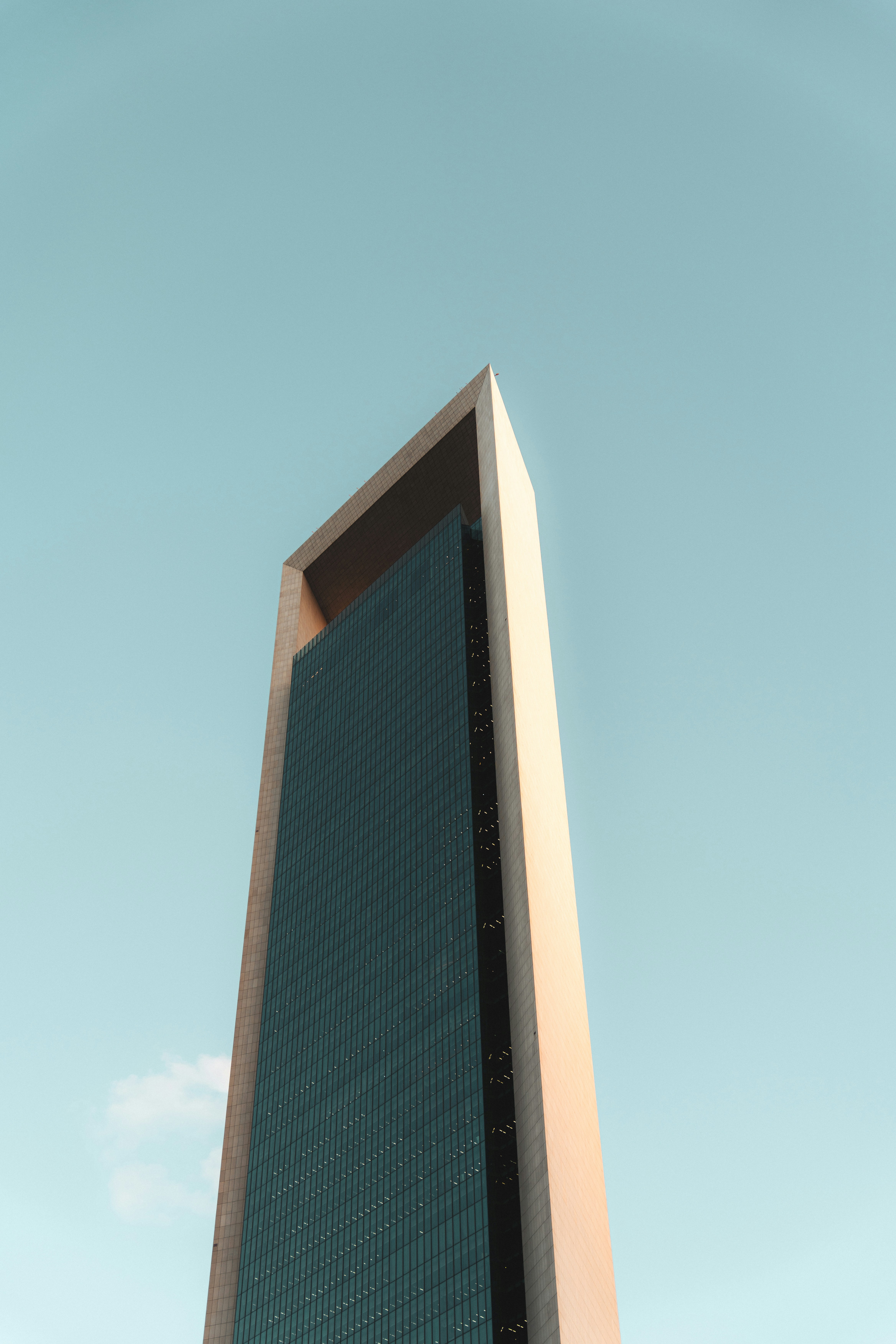 A tall, modern skyscraper stands against a clear blue sky.