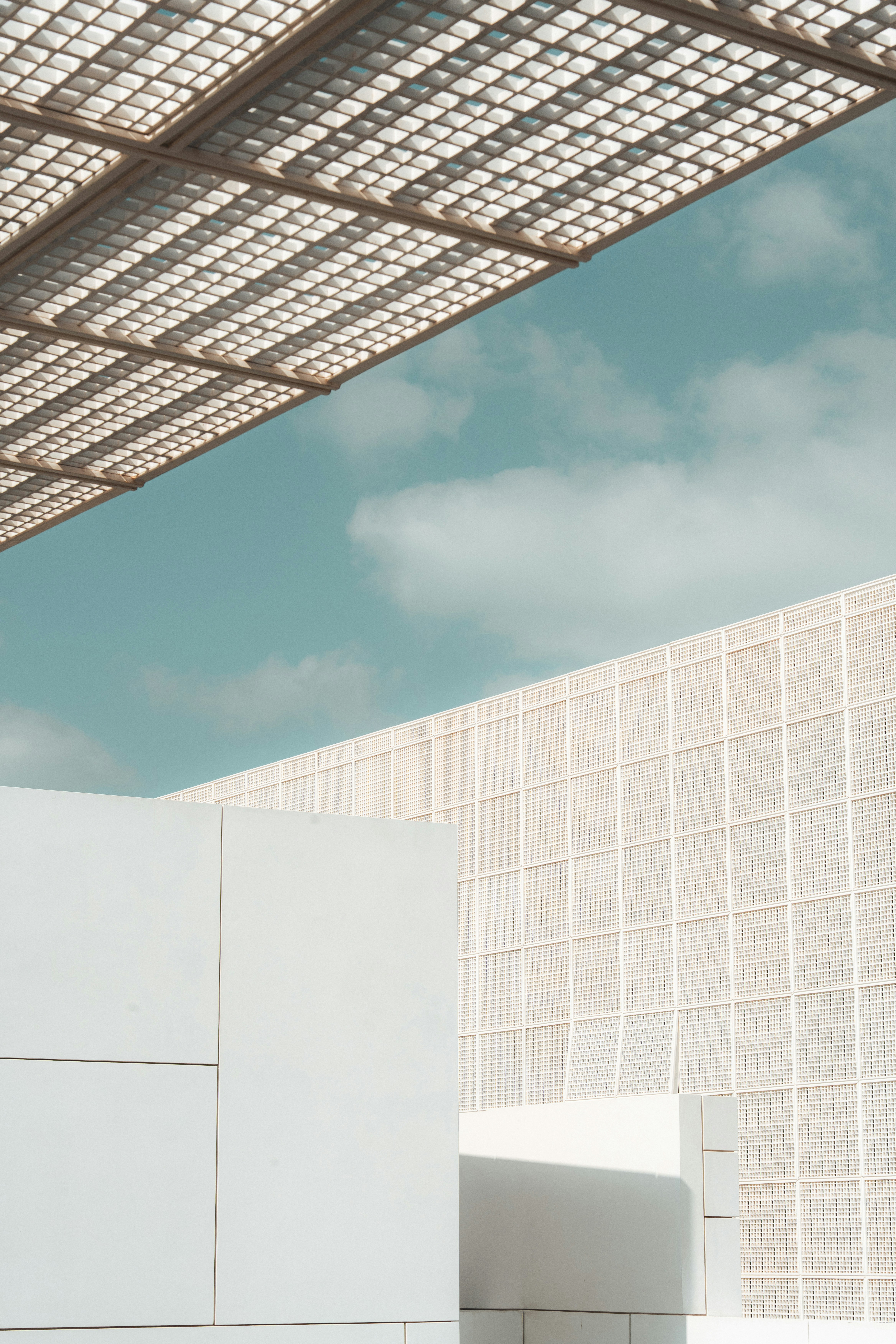 Modern white architecture under a patterned roof and blue sky