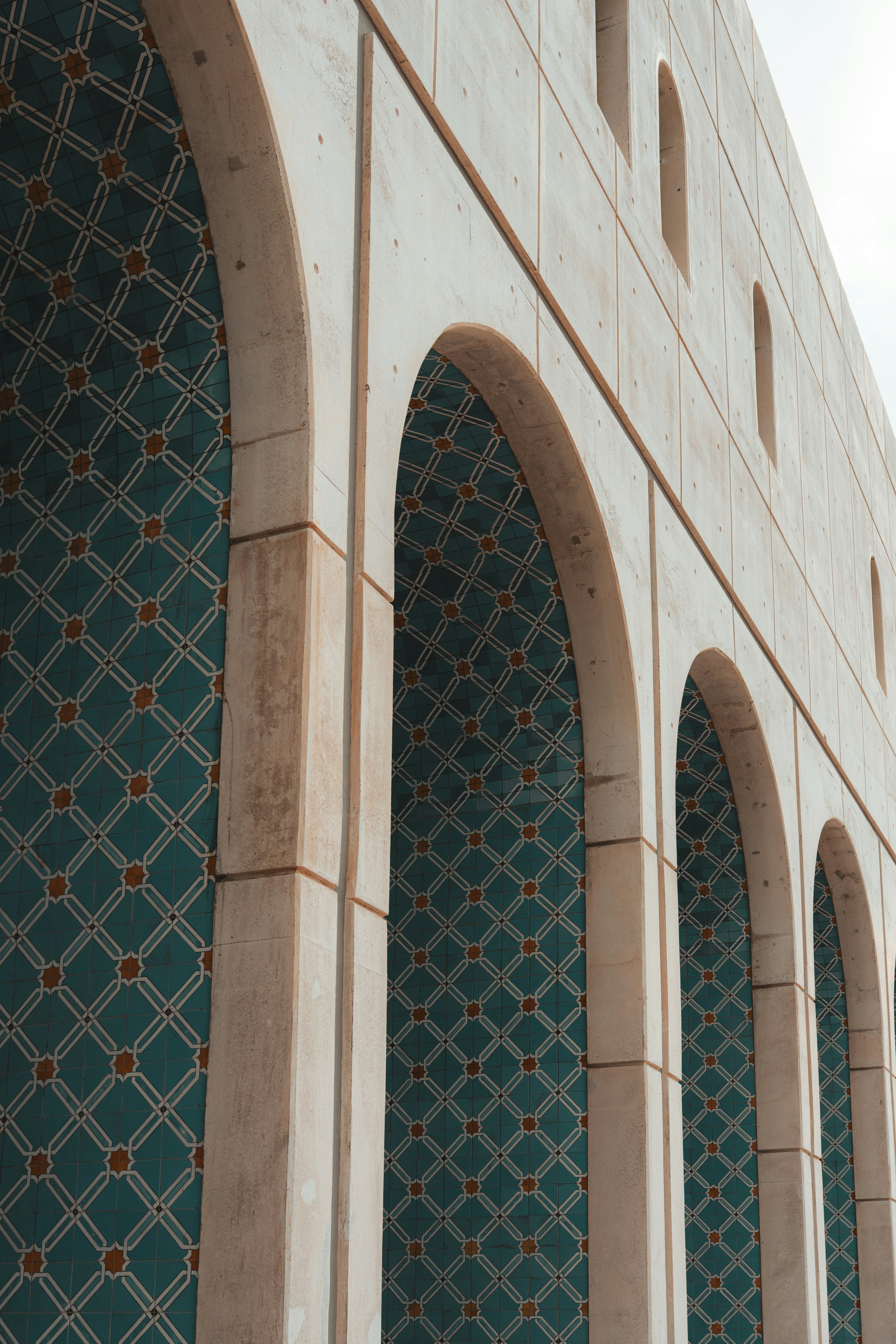 Arched building facade with teal and gold patterned interior.