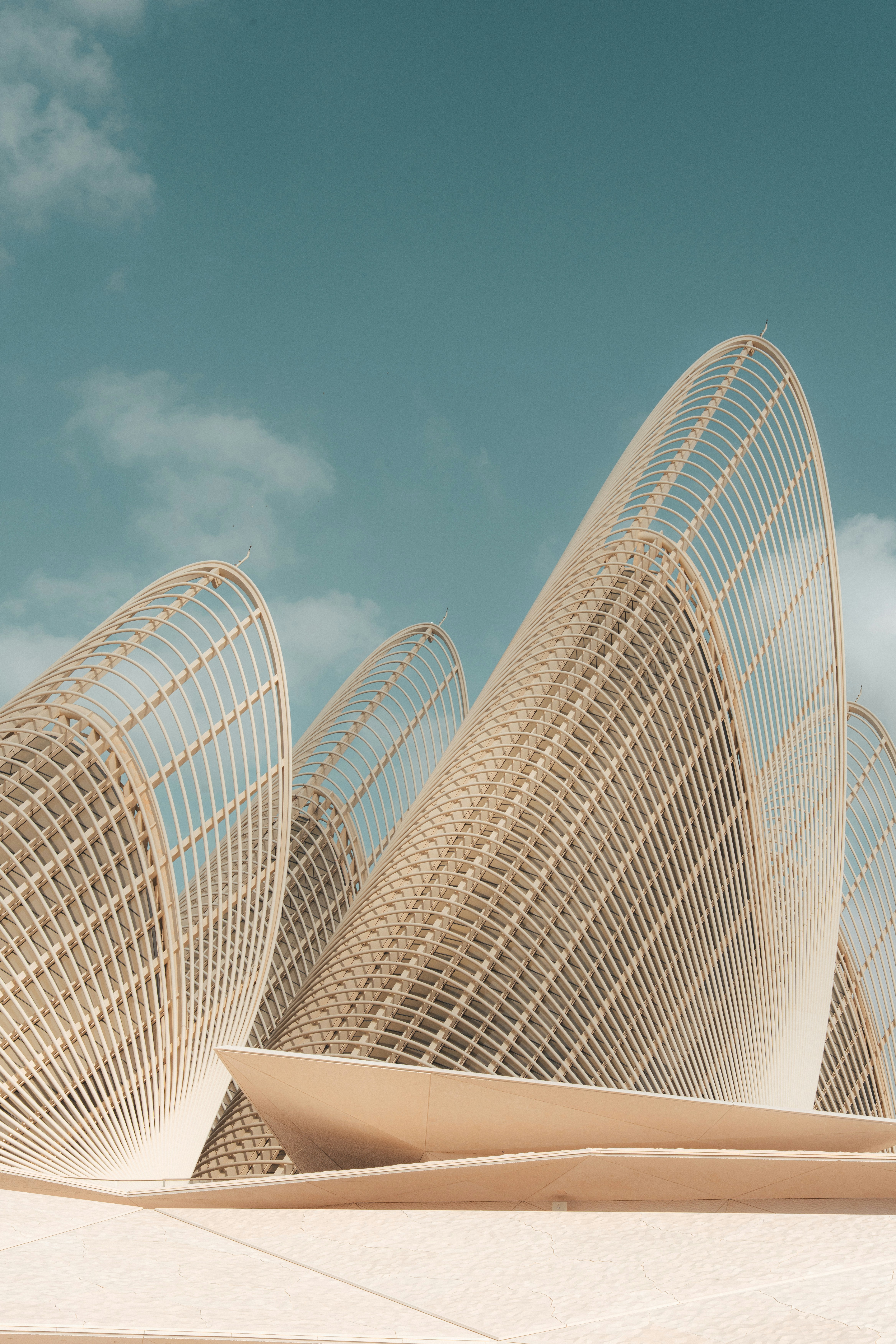 Abstract curved architecture under a clear blue sky.