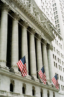 American flags adorn a classical building with imposing columns