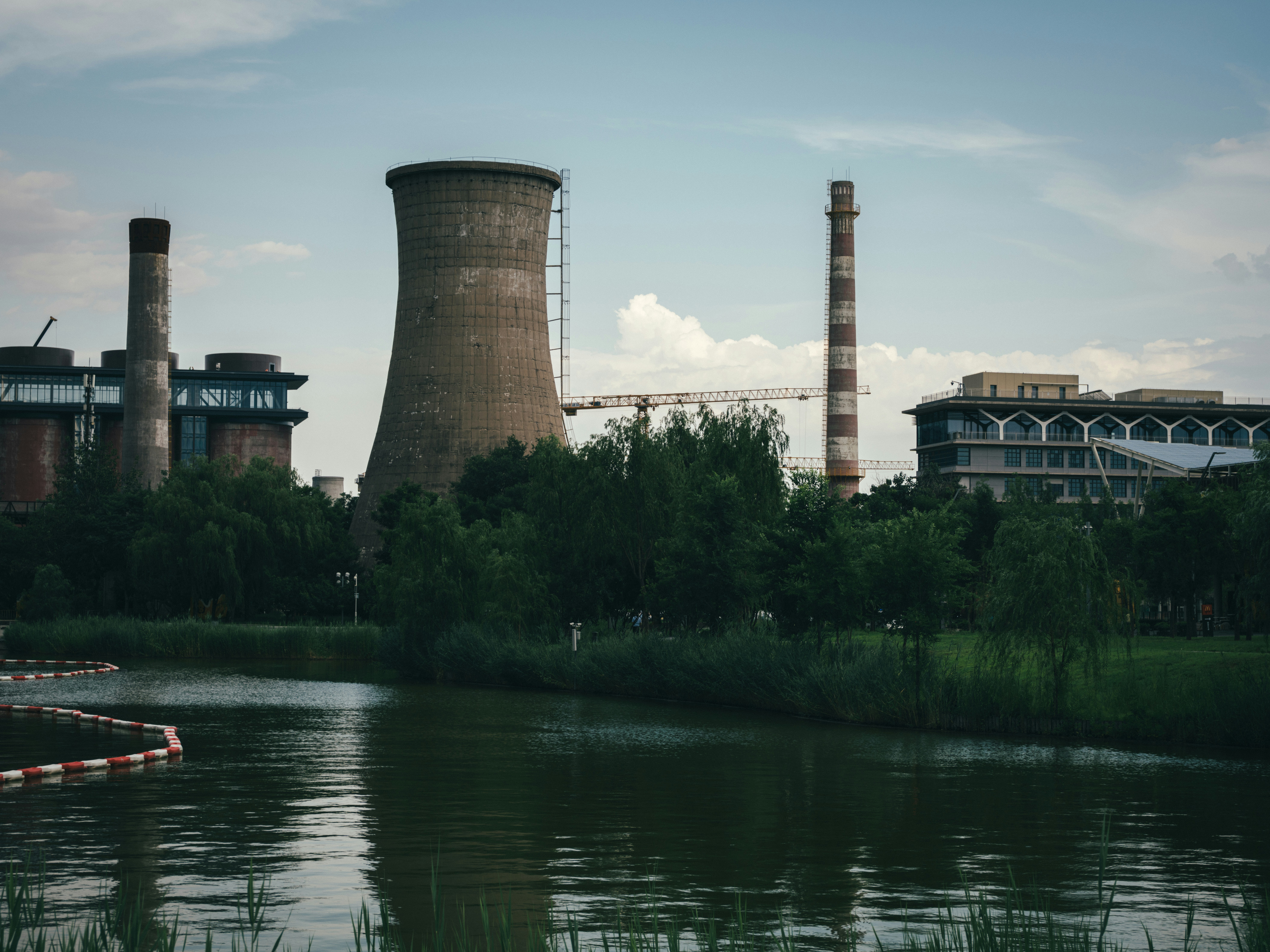 Industrial power plant with cooling towers beside a reflective river.
